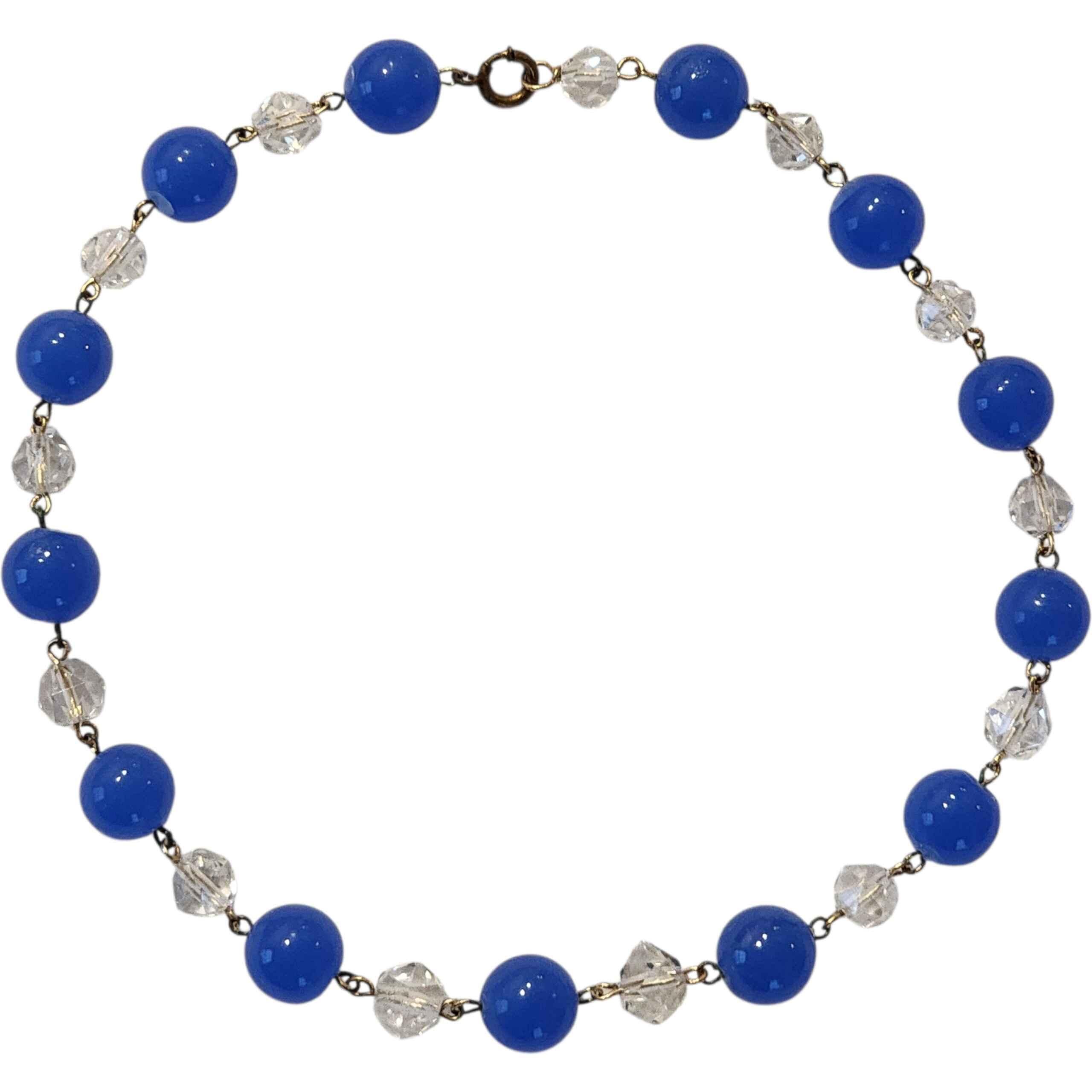 Collar vintage de 1930 de cristal azul cobalto y cristal transparente facetado, estilo art déco, enlazado a mano
Hermoso ejemplo de la artesanía de la bisutería de principios de siglo, este collar vintage de vidrio azul cobalto y cristal facetado