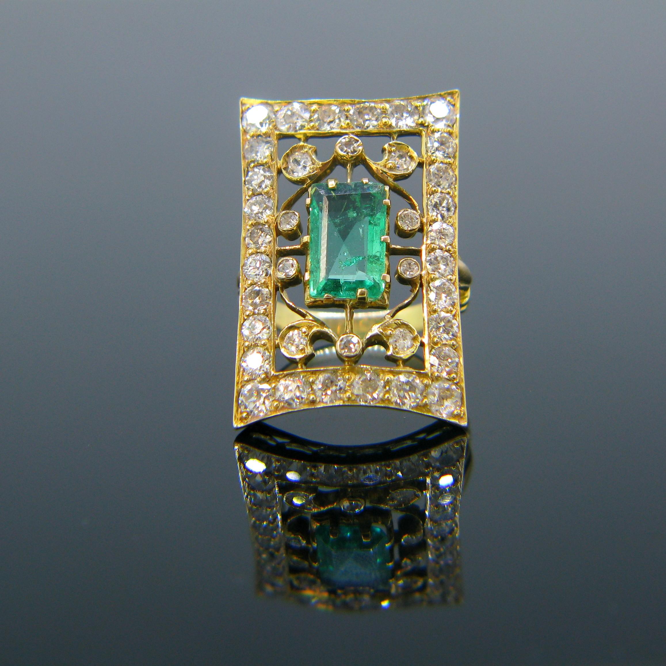 This rectangular shaped ring was made in the 1930s. It is set with an emerald weighing around 1.45ct. The ring has a beautiful design with scrollwork motifs. It is also set all around with old cut diamonds. The total diamond carat weight is around