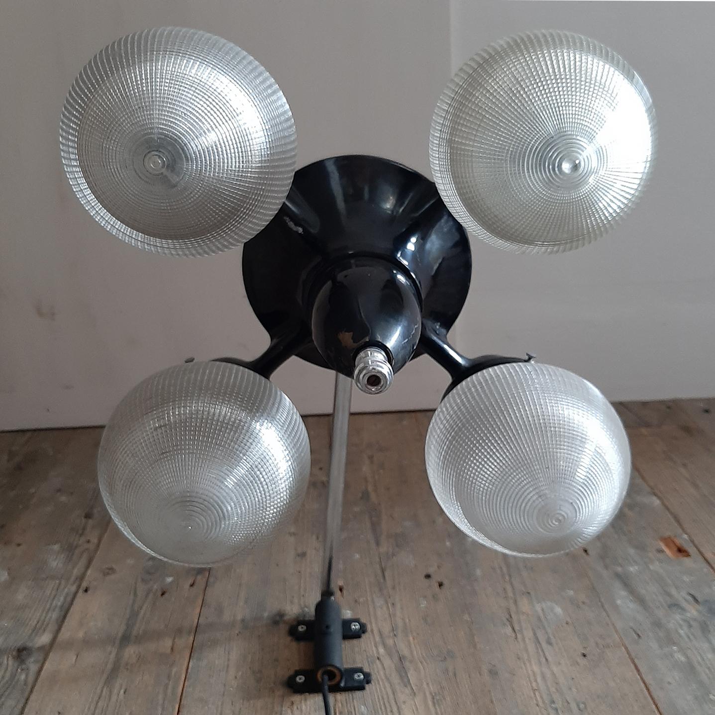 Vintage 1930s Holophane dentist overhead light. Industrial pendant lamp with a black steel body, four arms and four acorn shades. The lamp is fitted on a movable steel arm.

Measurements lamp: 28 x 40 x 40 cm
Measurements arm: 18 x 50 cm.