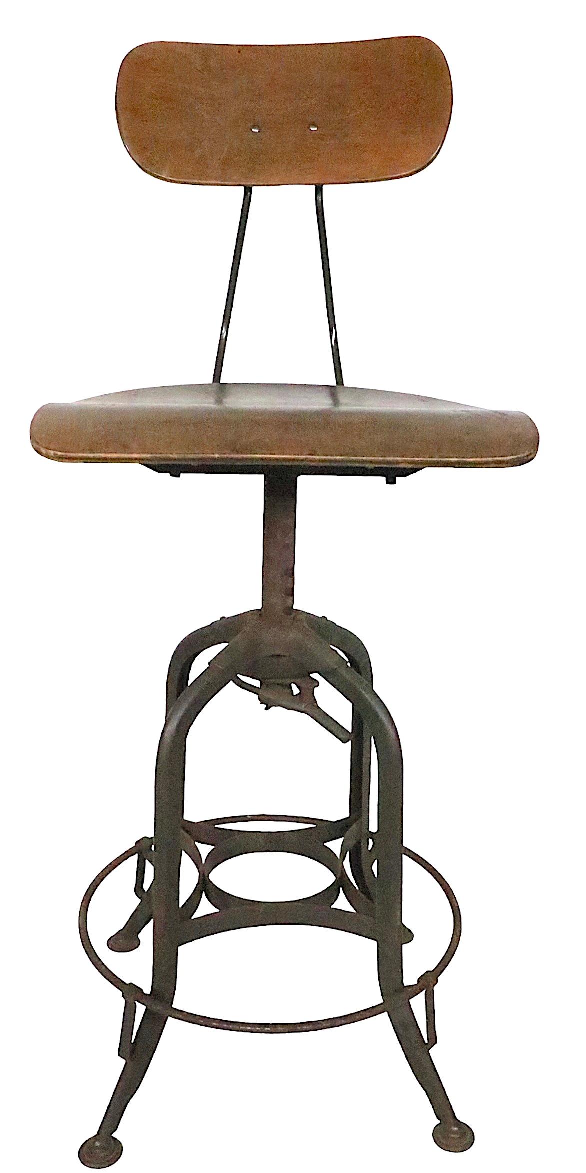 Tabouret de travail réglable classique de la Toledo Metal Furniture Company, Making Works, circa 1930. Le tabouret est doté d'une assise pivotante et d'un dossier inclinable et réglable en hauteur. Le réglage de la hauteur du siège permet de le