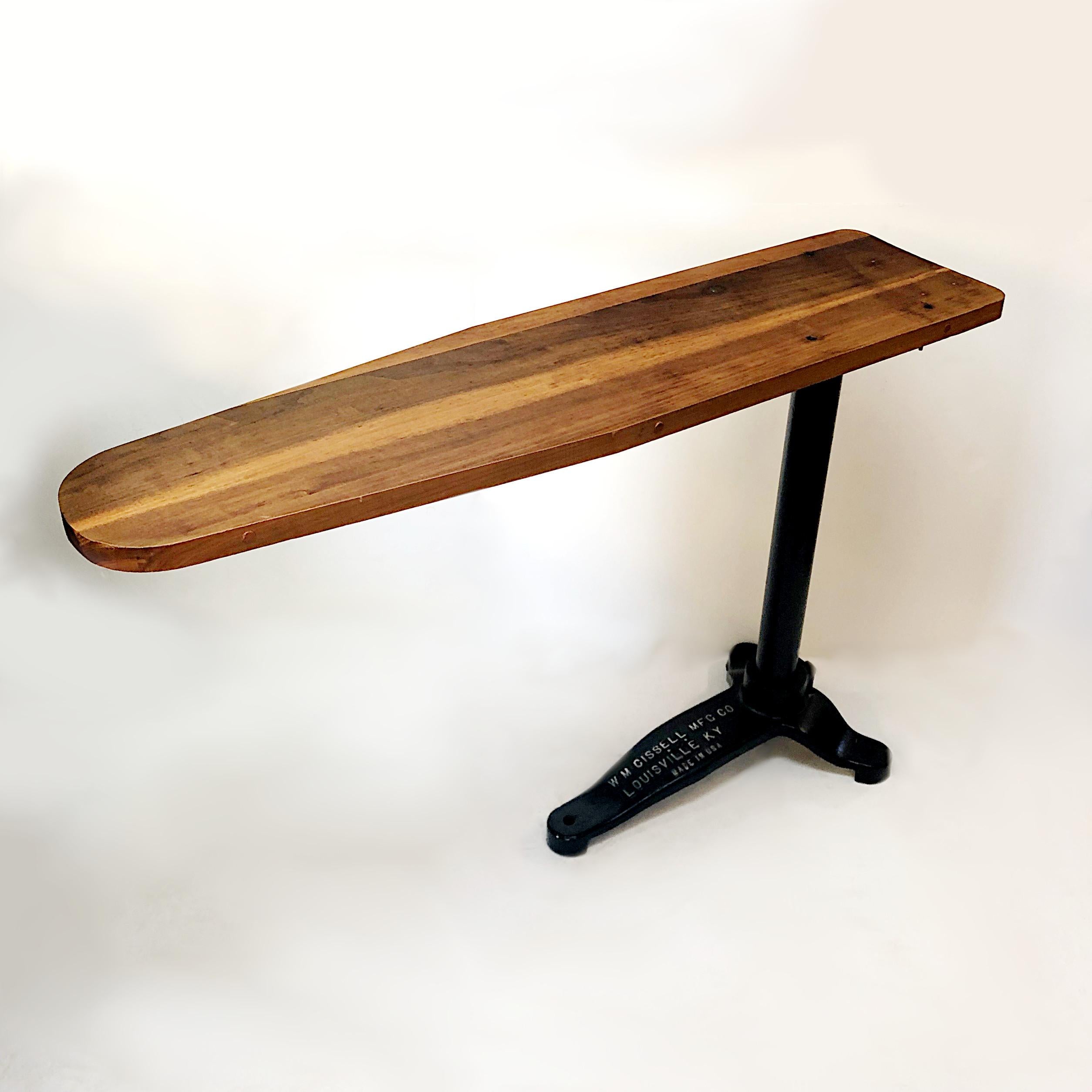 Cette planche à repasser industrielle des années 1930 de Cissell MFG. Co. de Louisville:: KY:: a été construit pour durer..... Avec sa base en fonte:: son poteau et son plateau en bois massif:: cette pièce a tout le charme industriel et constitue la