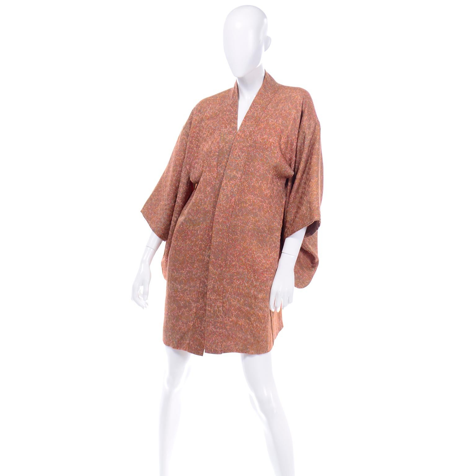 This pretty 1930's vintage Japanese silk haori kimono is in a tiny floral print in shades of orange, pink, lime, sage. The inside lining is a gorgeous Japanese printed garden scene in light pink, pale yellow, and orange. This is a shorter kimono