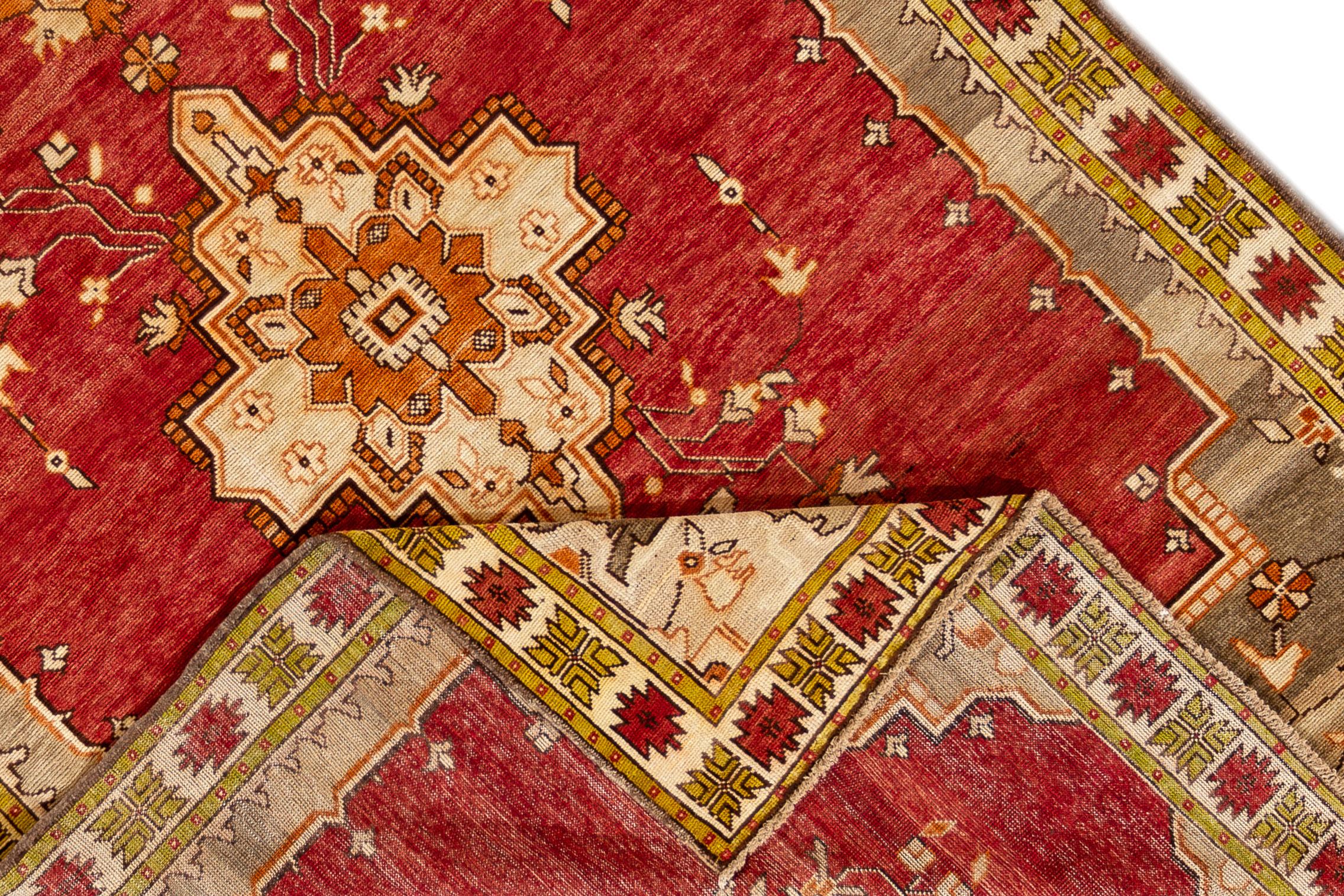 Vintage 1930s Khotan rug with a medallion design on a red field. Measures 6'5