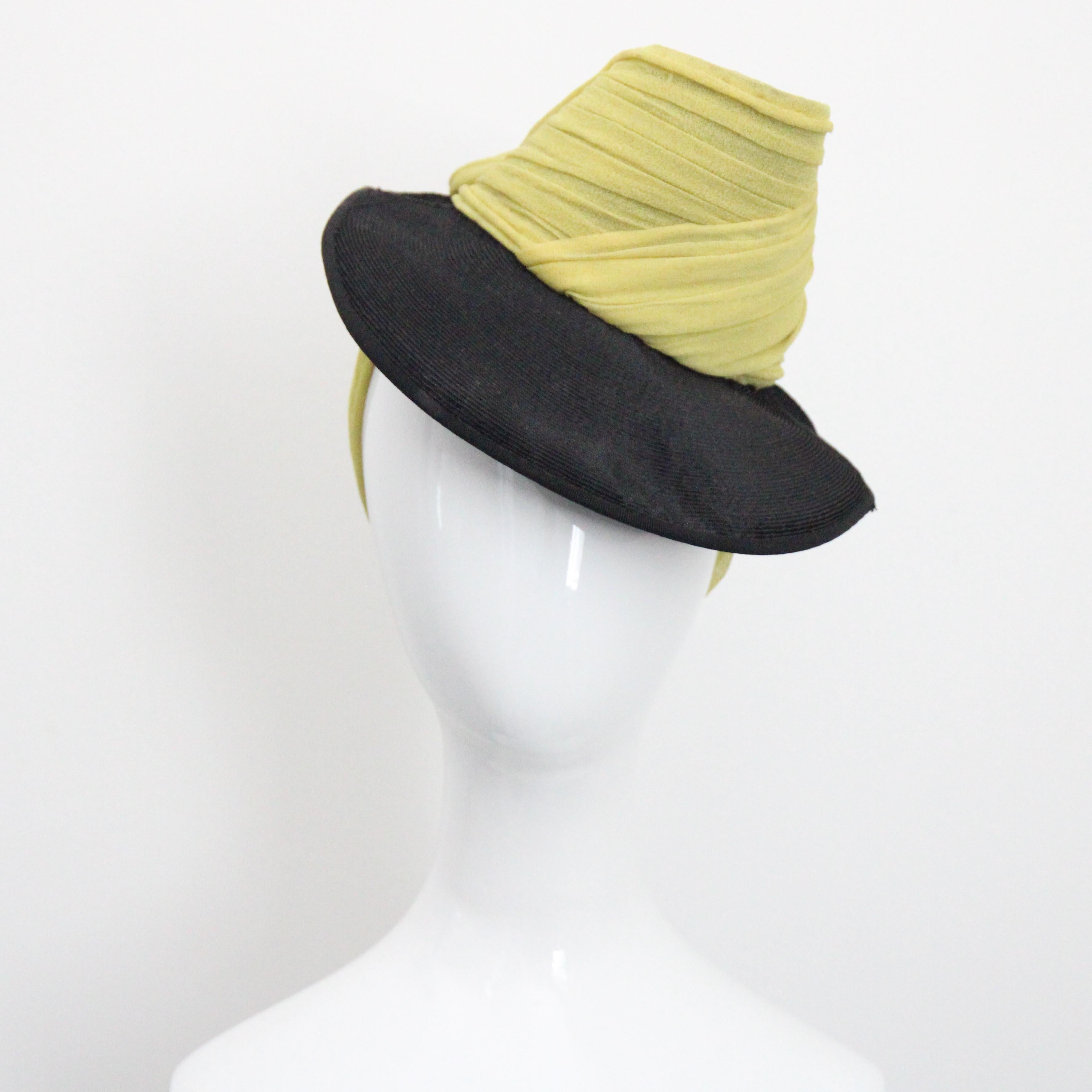 This beautiful and architectural 1930's straw and silk jersey hat, is a rare piece to behold. 
The high stylised open crown of the hat is accented by pleated chartreuse coloured silk jersey, contouring an angled open trilby crown feature. The curved