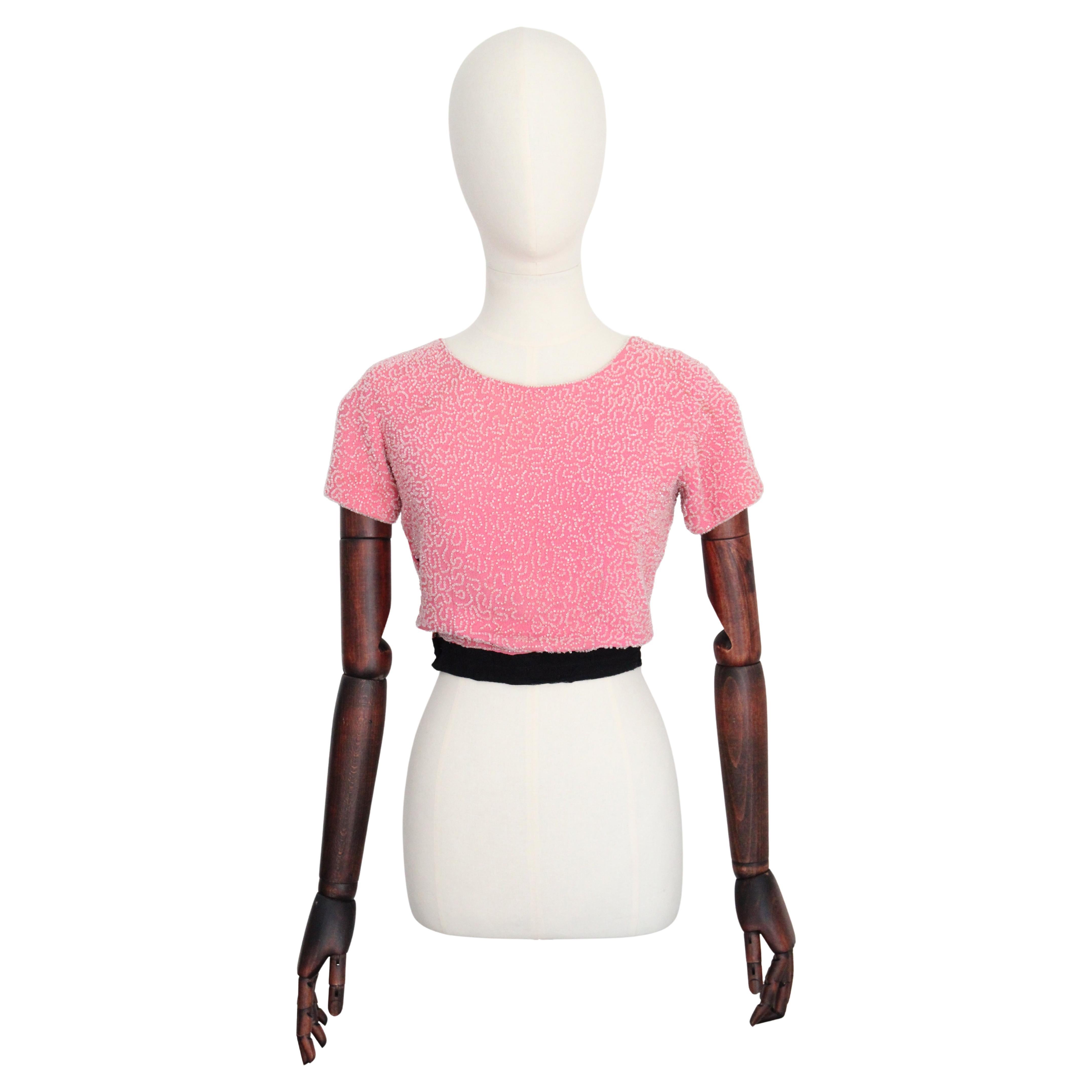 Realizzata nella più vibrante tonalità di seta crepe rosa, questa originale blusa degli anni '30, impreziosita da un motivo di perline in vetro trasparente, è il pezzo forte perfetto per la tua collezione vintage. 

La scollatura arrotondata della