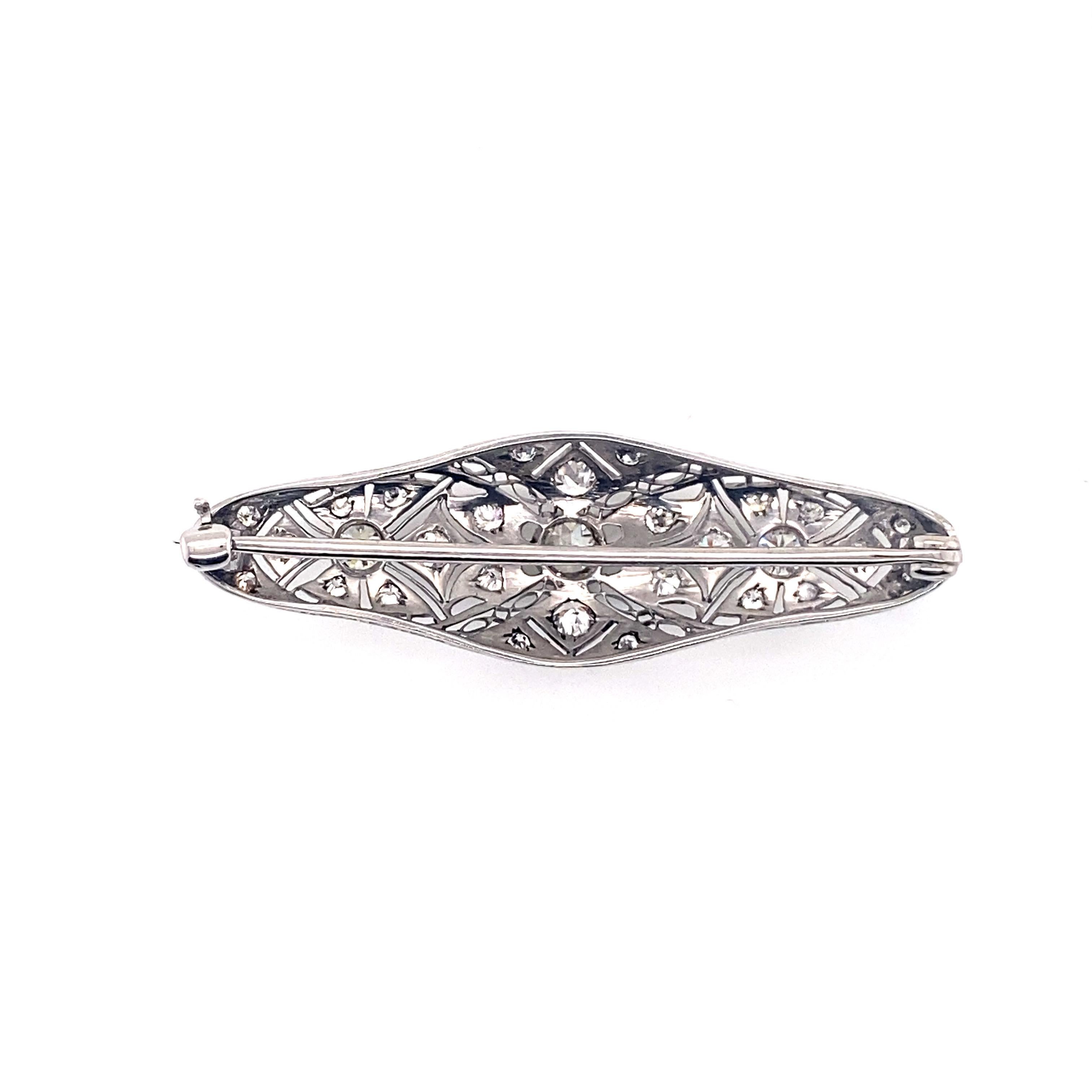 This exquisite brooch is a breathtaking example of the exceptional craftsmanship and artistry that defined the 1930s era. Rendered in lustrous platinum, it showcases an intricate filigree design adorned with dazzling diamonds, creating a true