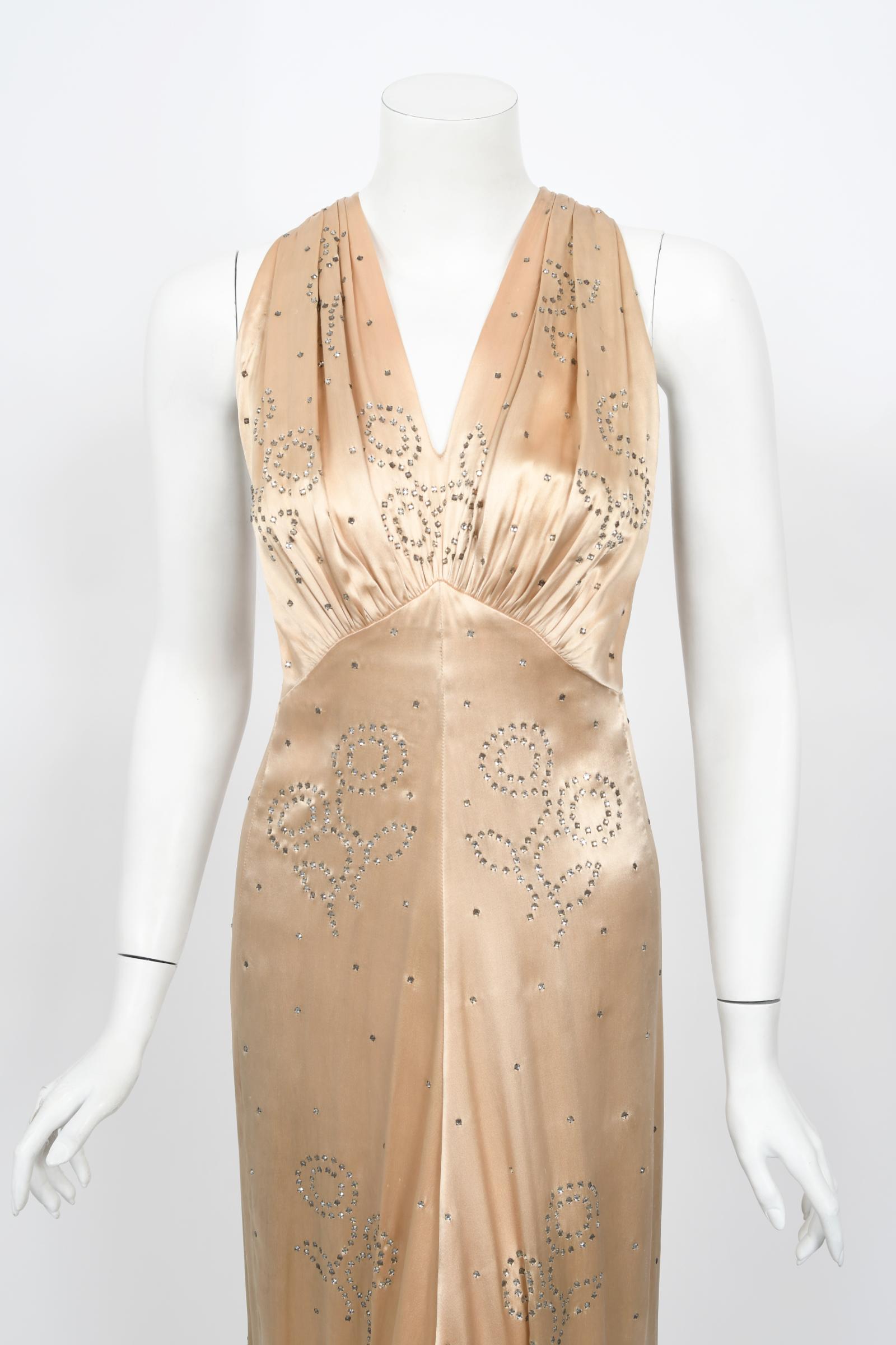 A breathtaking candlelight blush silk satin gown dating back to the mid 1930's Old Hollywood era of glamour. So Ginger Rodgers! I have never seen such a romantic design; hundreds of sparkling prong-set rhinestones in an alluring deco floral motif.