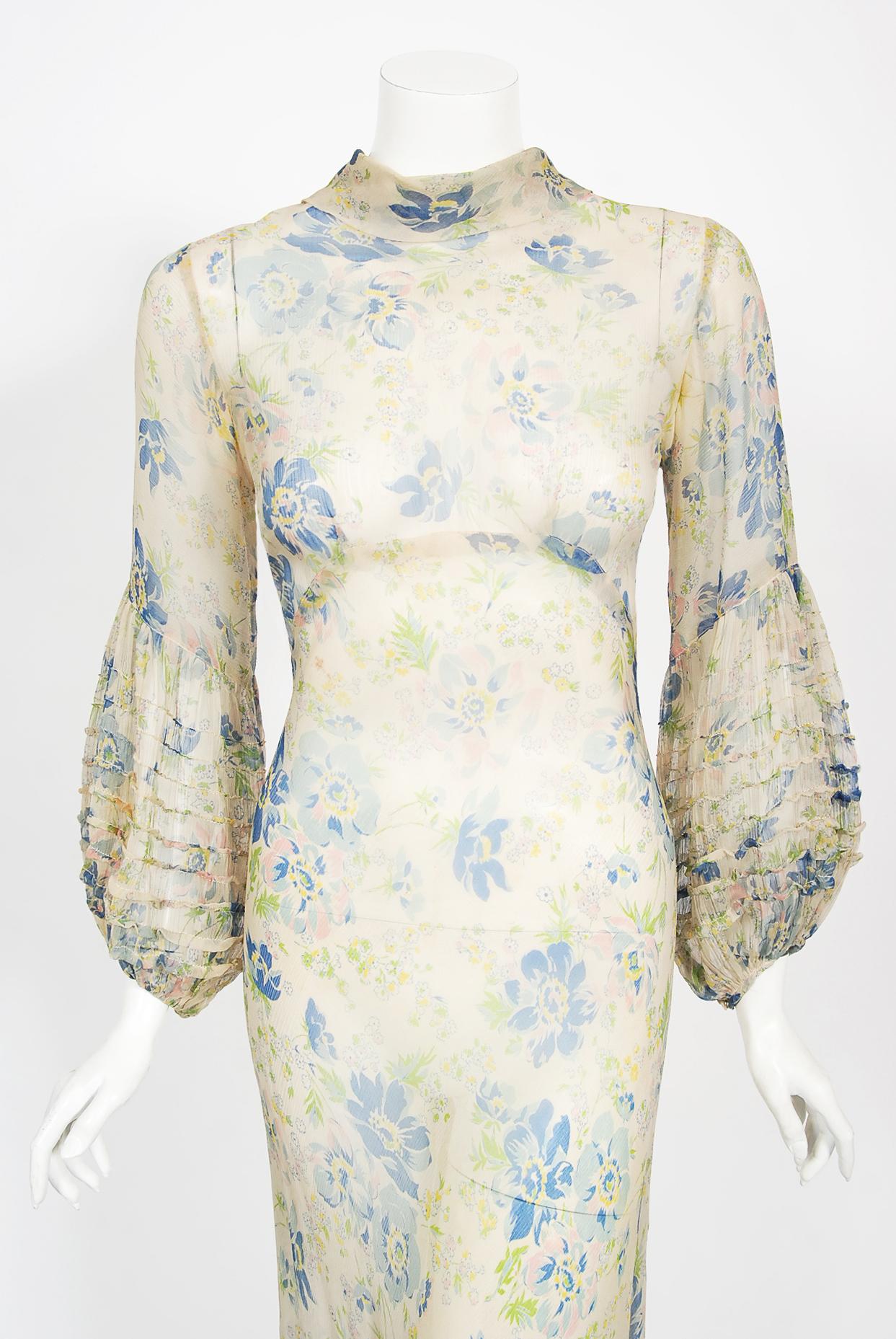 The ethereal floral garden print used on this 1930's sheer ivory silk chiffon gown has a fresh innocence that I find irresistible. The bodice has a sculpted high-neck with dramatic pintuck billow sleeves. The garment can also work backwards so we