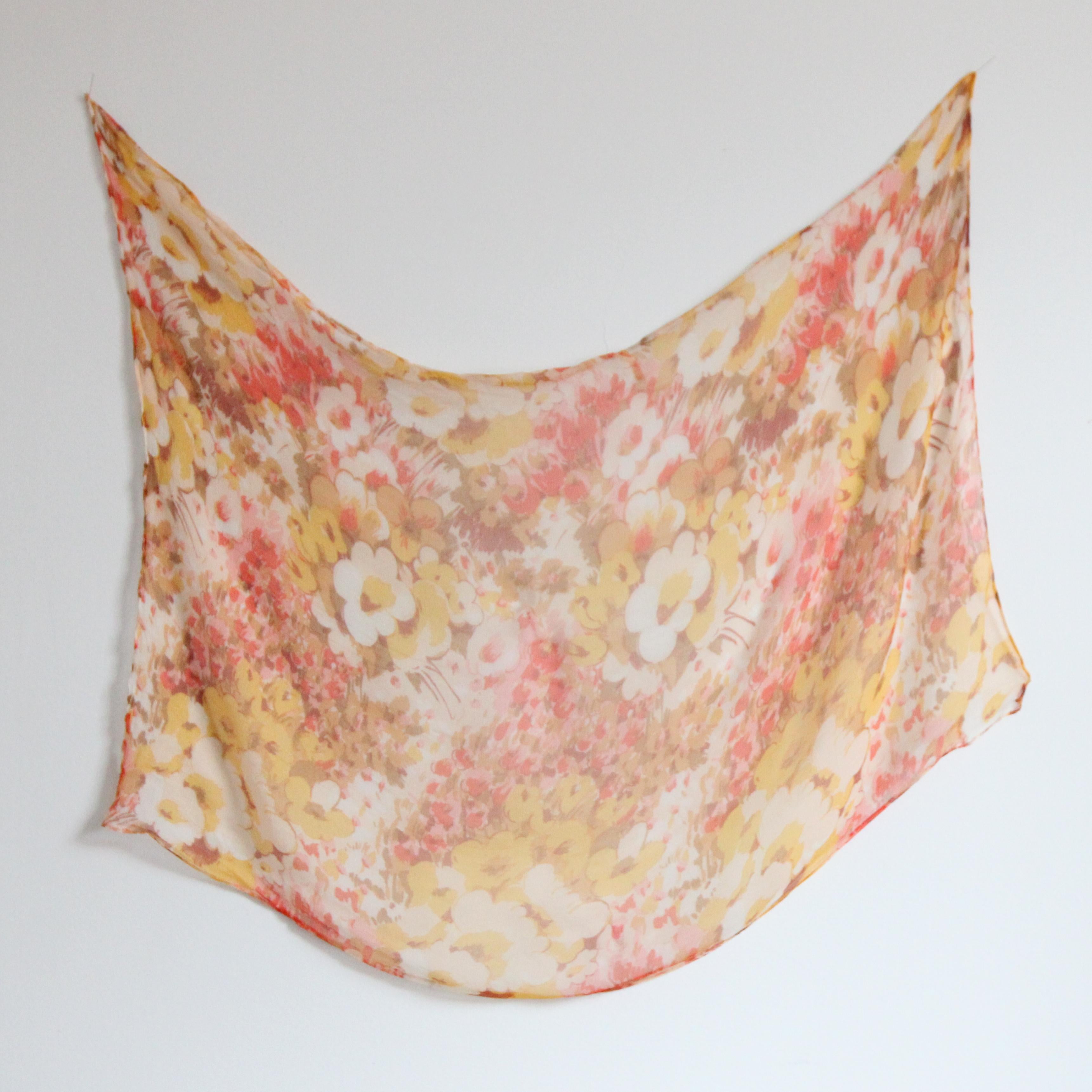 Réalisé dans une palette de soleil levant, dans des tons de jaune, orange, rouge, marron et rose sur un fond crème, ce foulard original en mousseline de soie florale des années 1930 sera certainement l'un des accessoires favoris de votre collection.