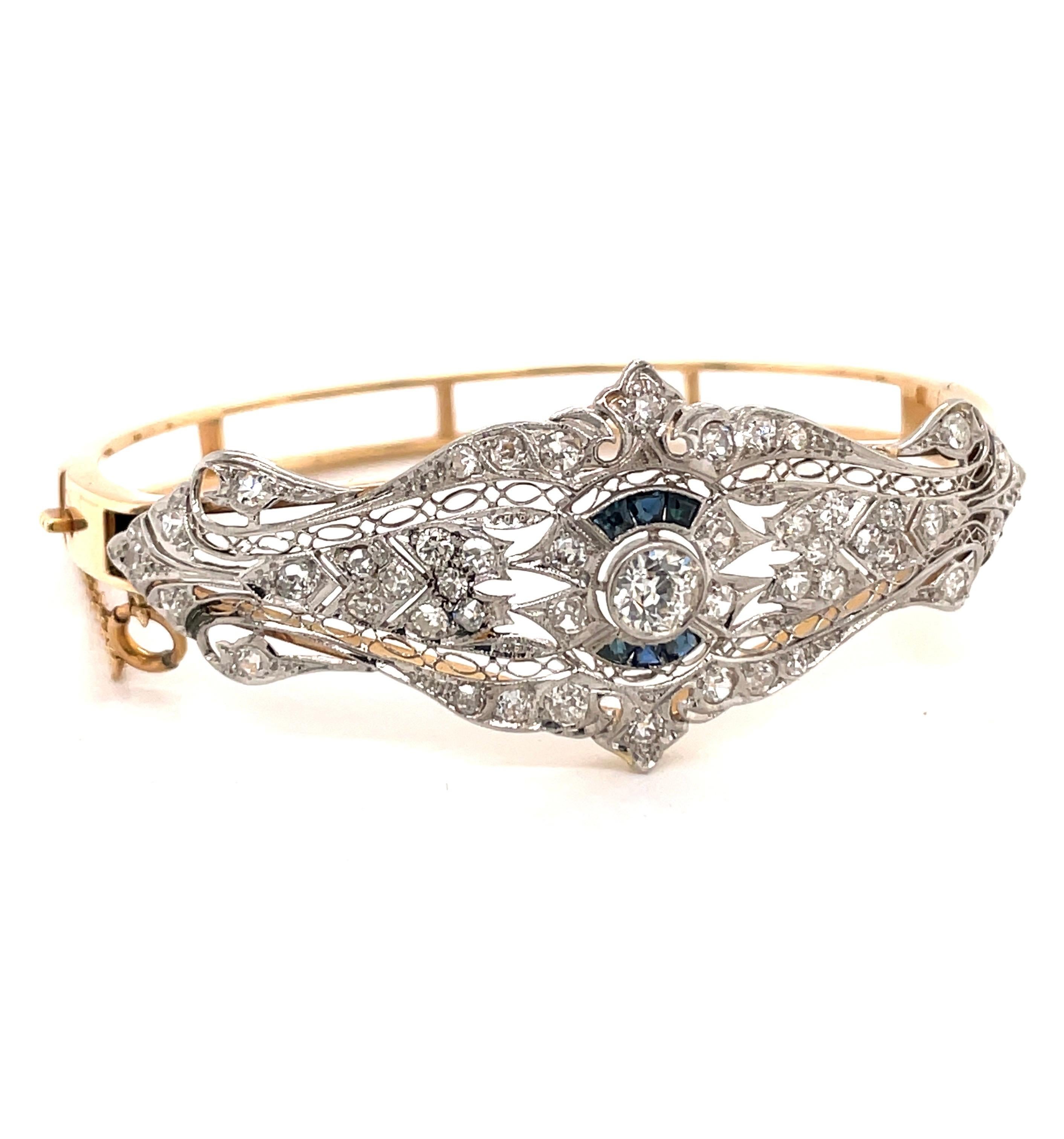 Vintage 1930's Whie Gold and 14K Yellow Gold Diamond Bangle Bracelet - The bangle contains one European cut diamond bezel set set that weighs approximately .50ct with I color and VS2 clarity. There are 6 trapezoid sapphires channel set with