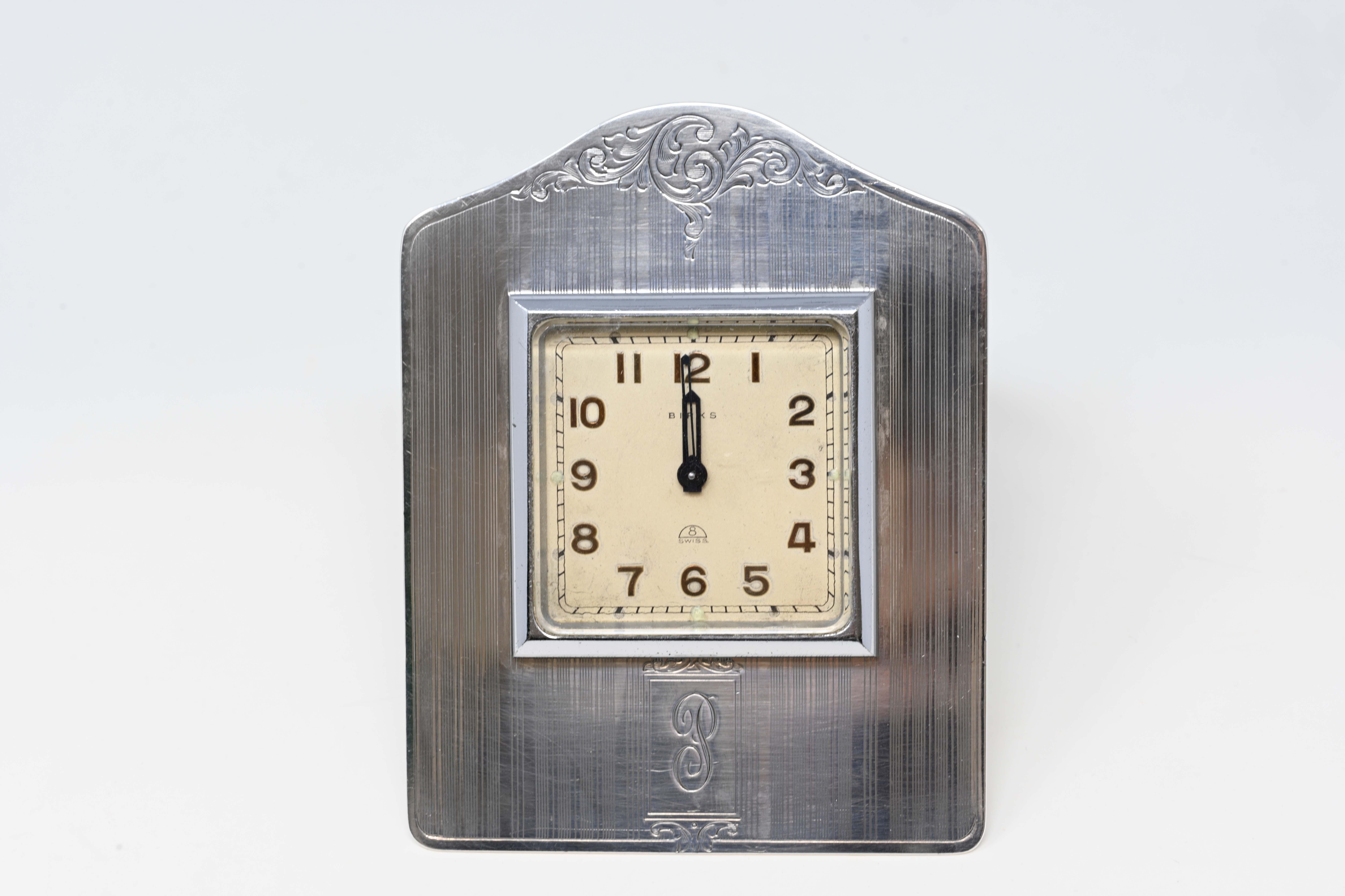 1939 Birks sterling silver desk clock stamped on the back. Movement was made in Switzerland, case was made in Canada. With a white dial and arabic numerals, family monogram on the front. Measures 4 1/2 inches tall x 3 1.2 inches. In good working