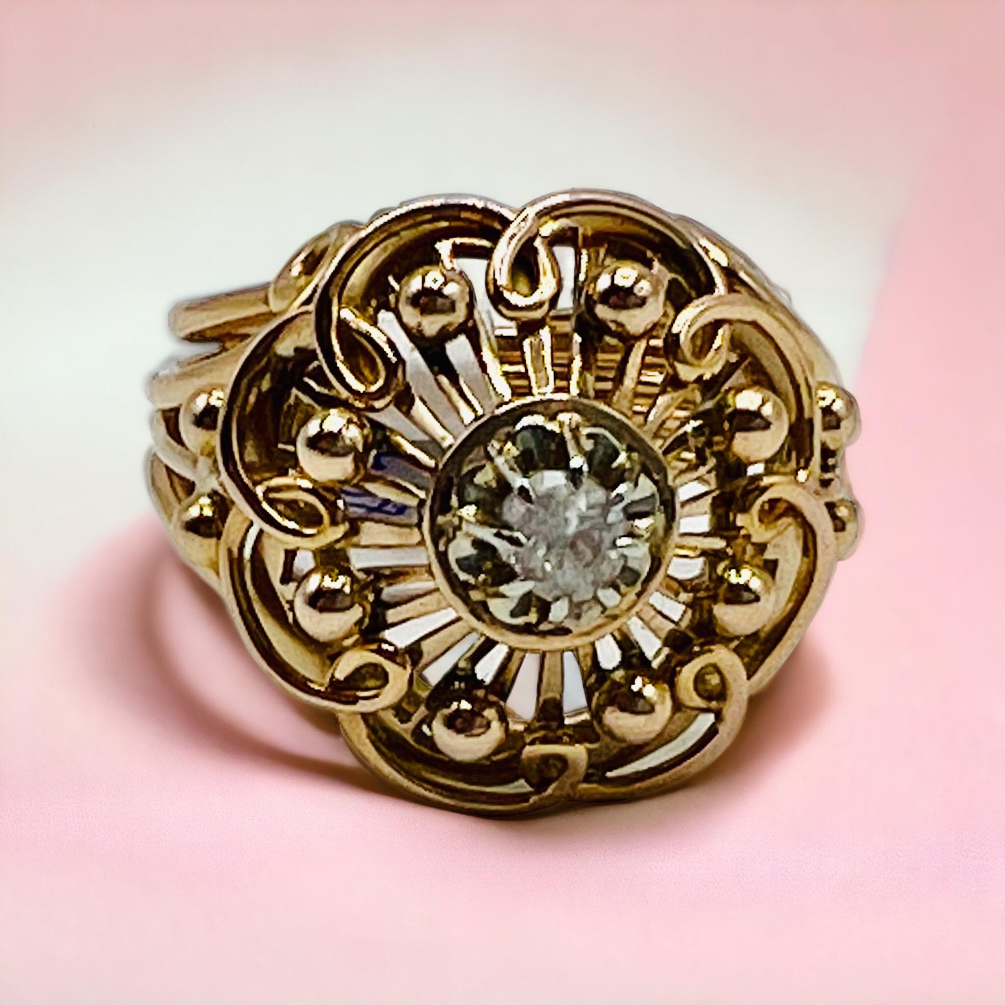 A charming 18K yellow gold ring from the 1940s, featuring a sparkling white gemstone of approximately 0.18 carats. This vintage piece, weighing 7.39 grams, reflects the timeless elegance and craftsmanship of its era.

The ring size is 52 (US 6),