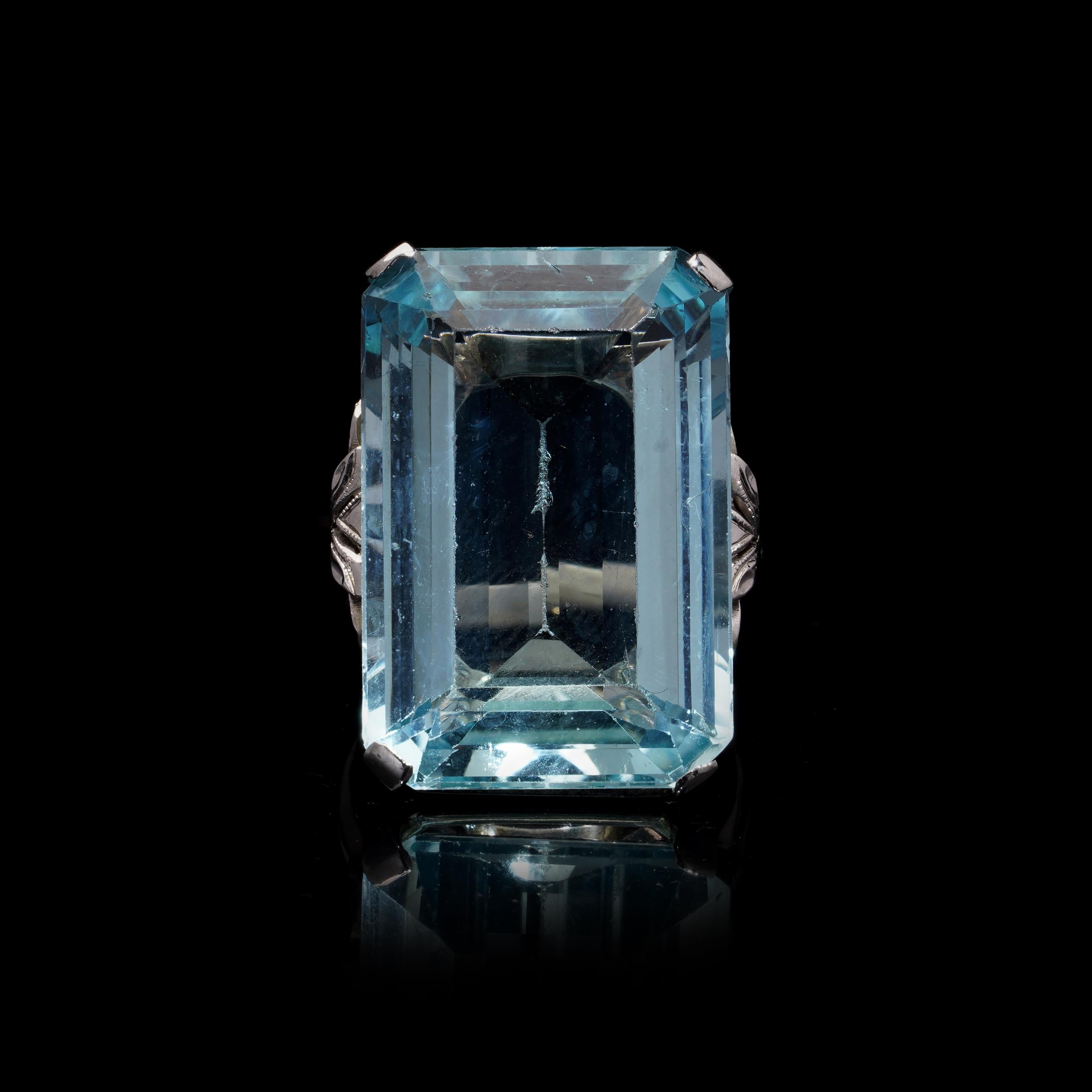 Vintage 1940s 18kt Gold Natural Aquamarine Ring

This stunning vintage ring from the 1940s showcases a beautifully cut emerald-shaped aquamarine, weighing approximately 20 carats. The striking blue hue of the aquamarine is complemented by the fine