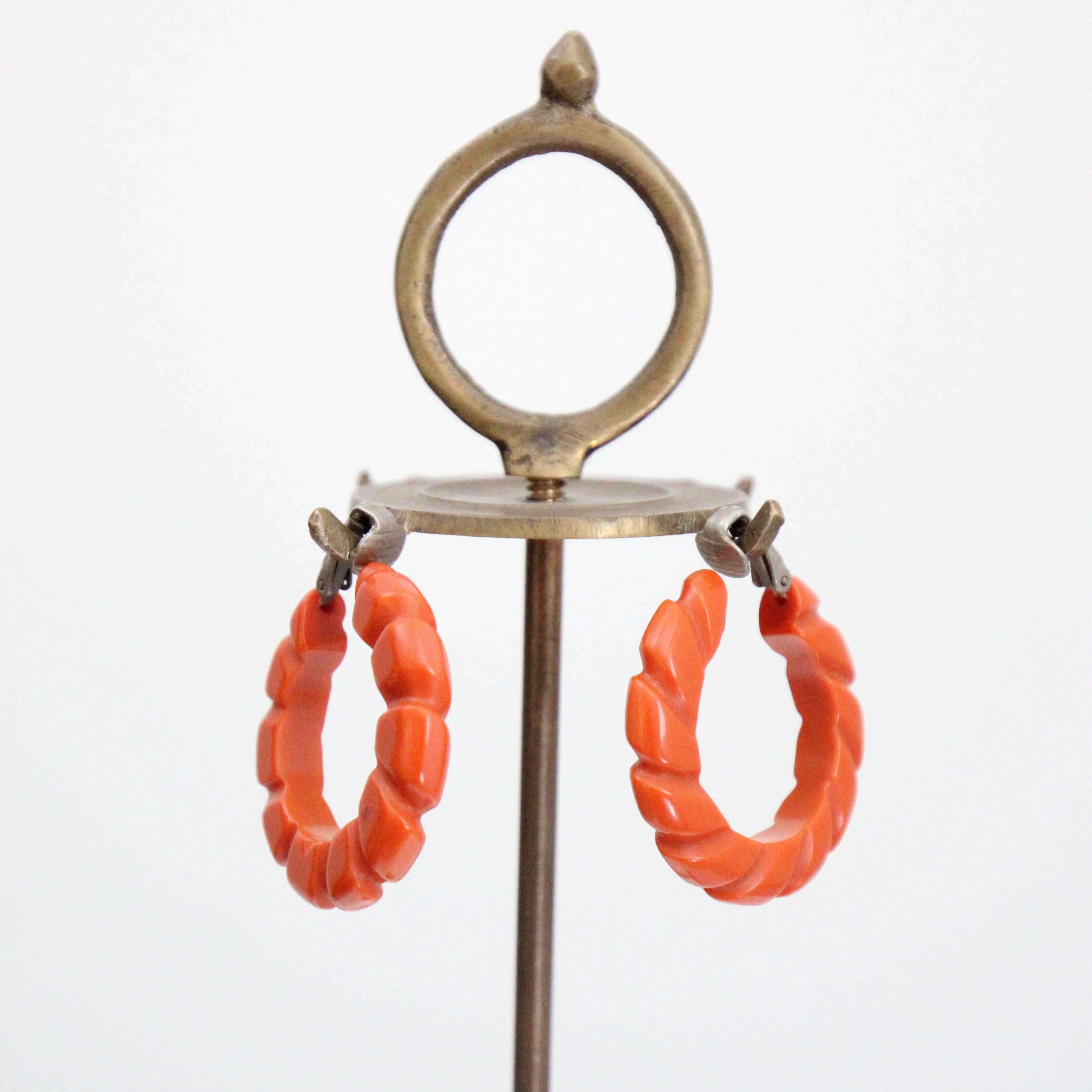 Cette magnifique paire de boucles d'oreilles à clip des années 1940, dans une nuance vibrante de bakélite ambrée, finie avec des détails sculptés dans un design de corde torsadée, est la touche finale parfaite pour votre tenue.

Longueur : 1.4