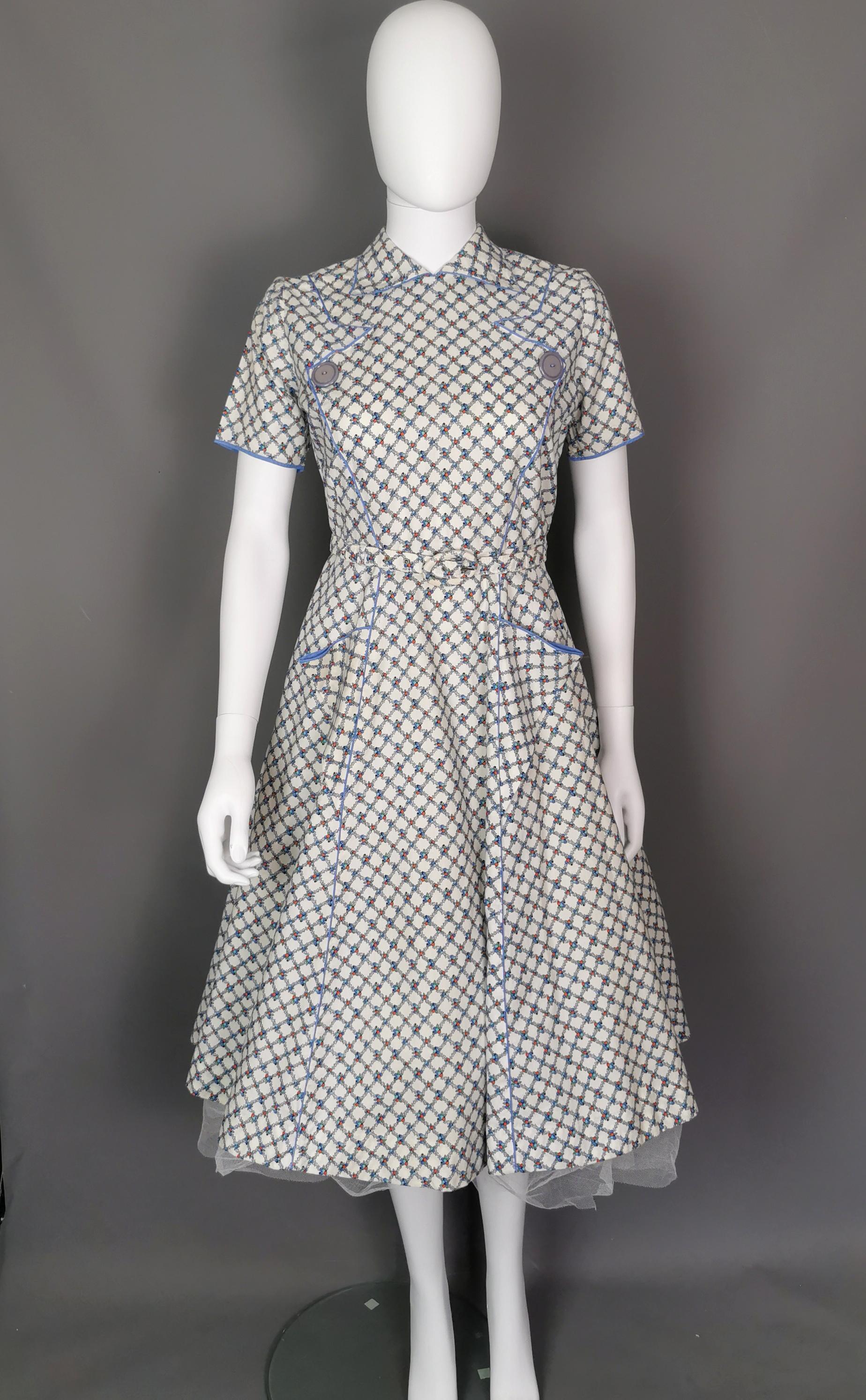 A rare vintage late 1940s pinafore style dress.

This dress gives vintage American diner vibes with it's short pointed collar, pinafore style button detailing and full skirt silhouette.

It is made from soft cotton with an unusual fruit basket
