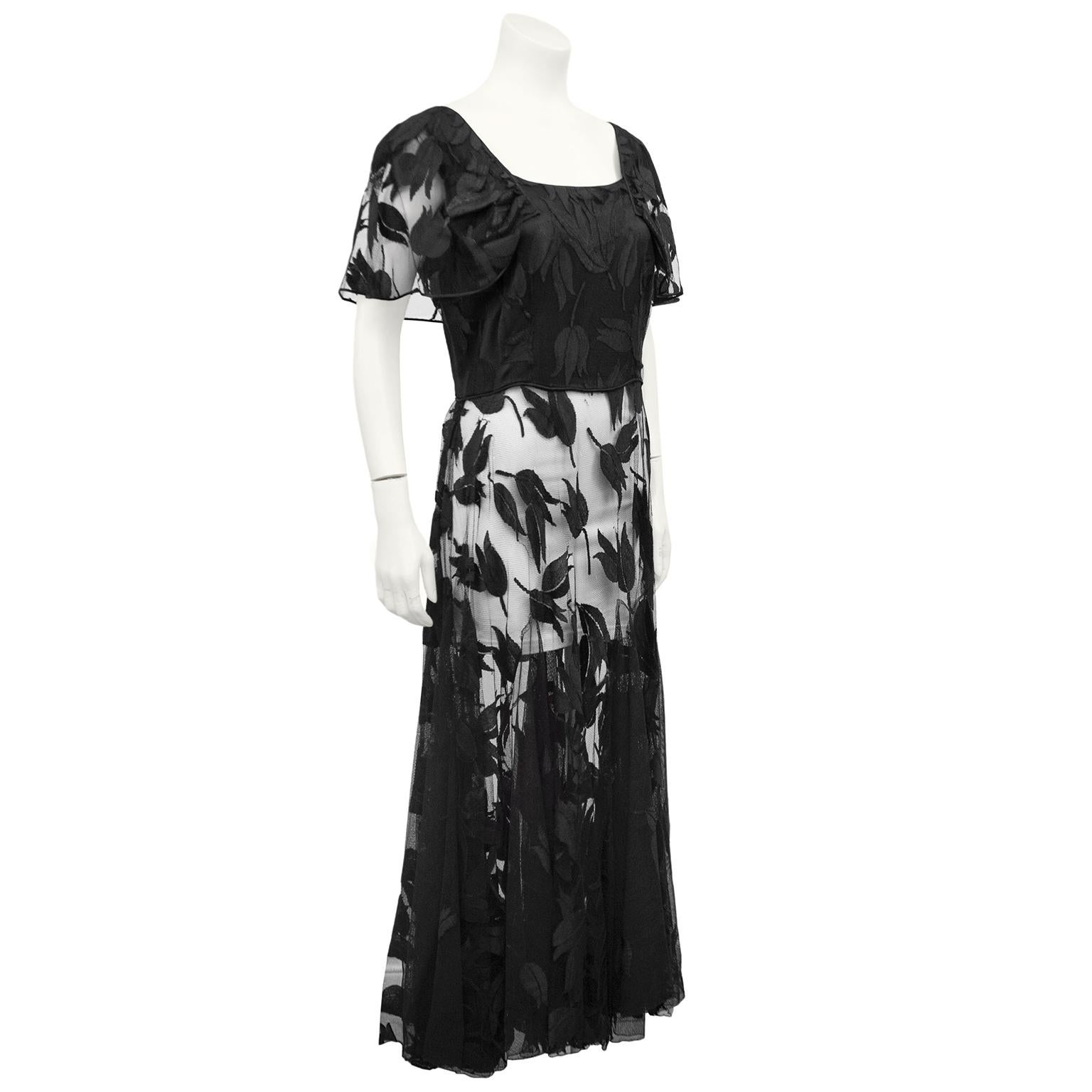 1940's black net and floral motif gown with short sleeves in excellent condition. Slim fit through the waist sits close to the body. Lined with black on the bodice. Would look so modern with black leggings for an at-home hostess look. Seems as if