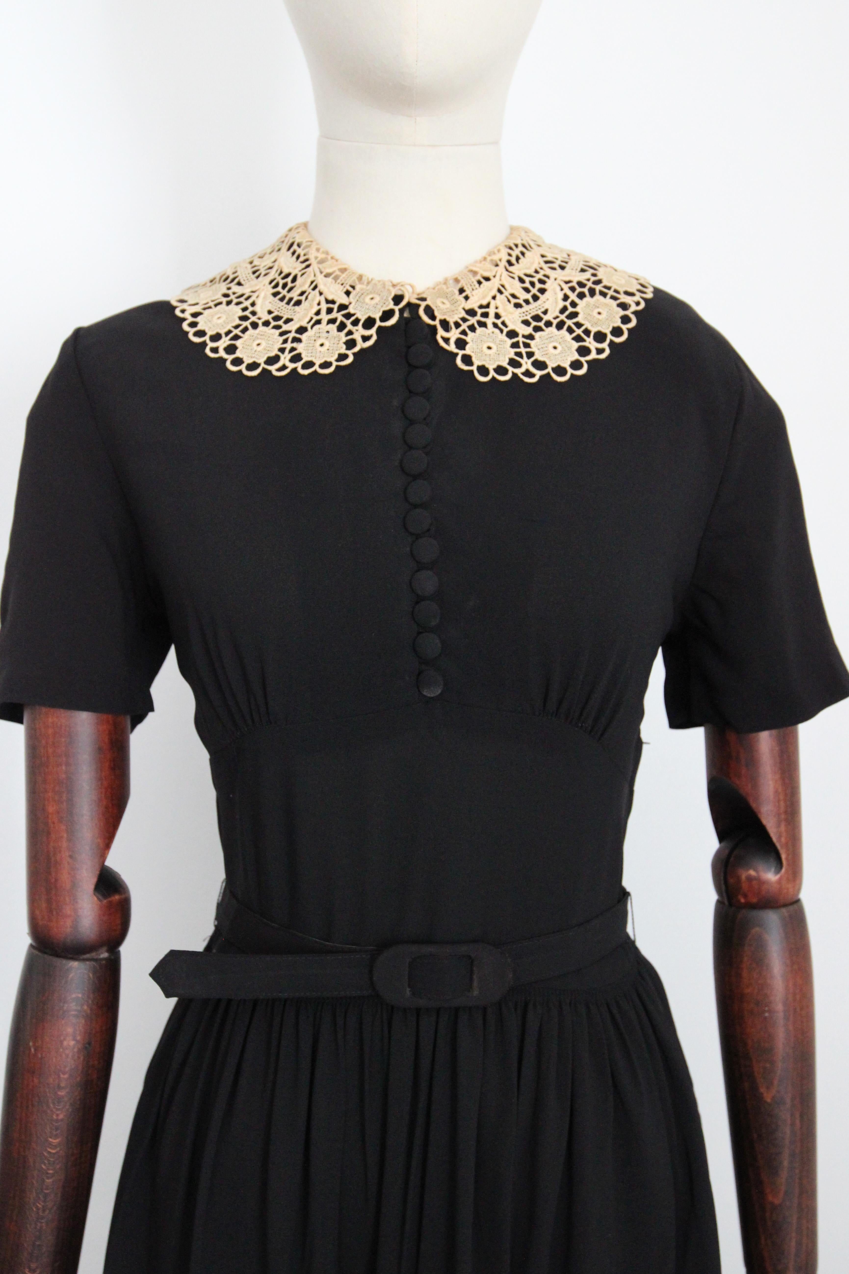 his darling 1940's black crepe silk dress, accented by a cream floral lace collar, is just the piece to add to your classic vintage collection.  

The elegant rounded neckline, is framed by a cream coloured softly scalloped floral collar, which
