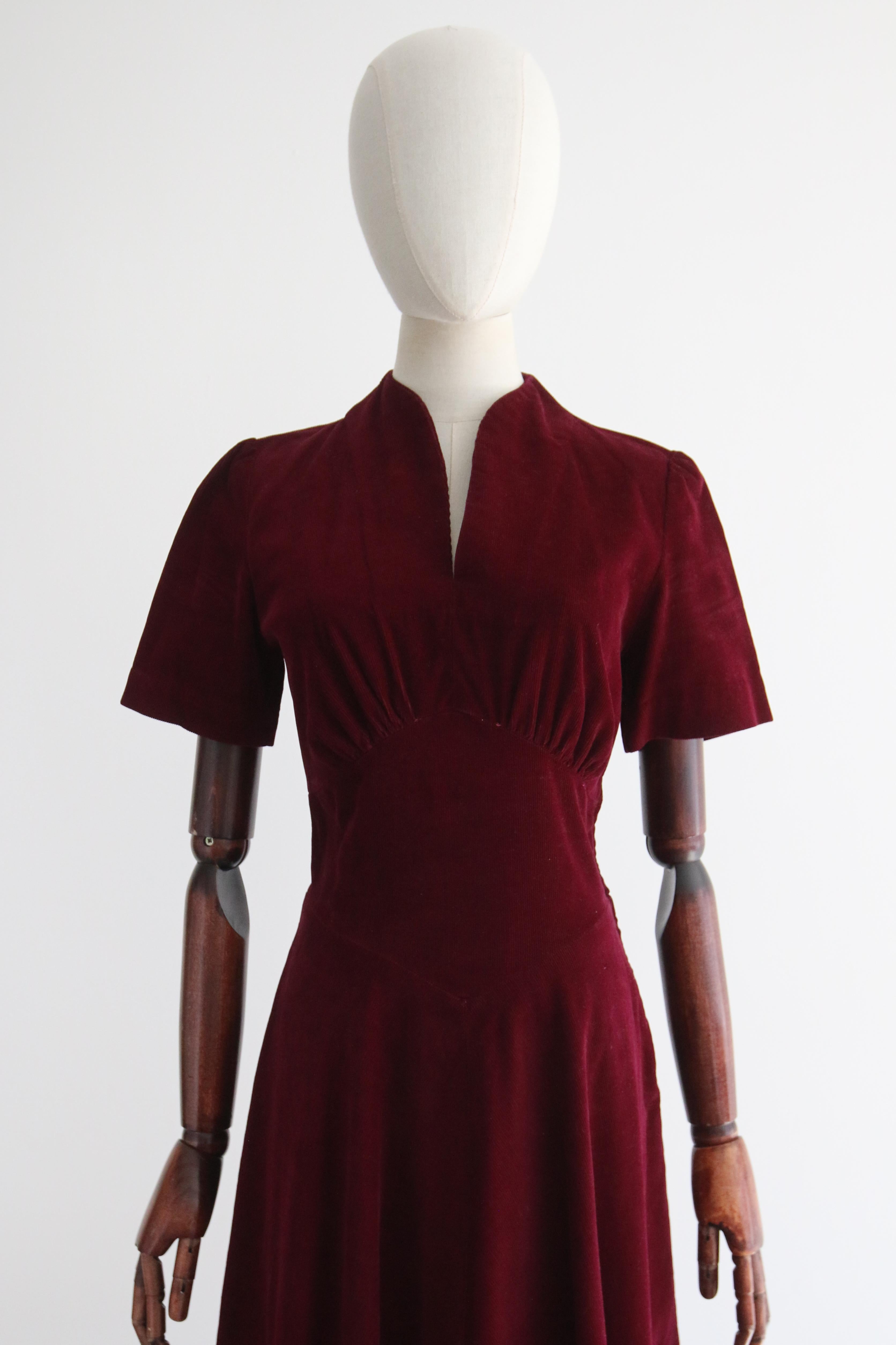 This wonderful 1940's dress rendered in a deep shade of Bordeaux corduroy, is just the piece to welcome to your seasonal wardrobe. 

The slim V shaped neckline is framed by a simple shoulder line. The short length sleeves boast slim gathered pleats