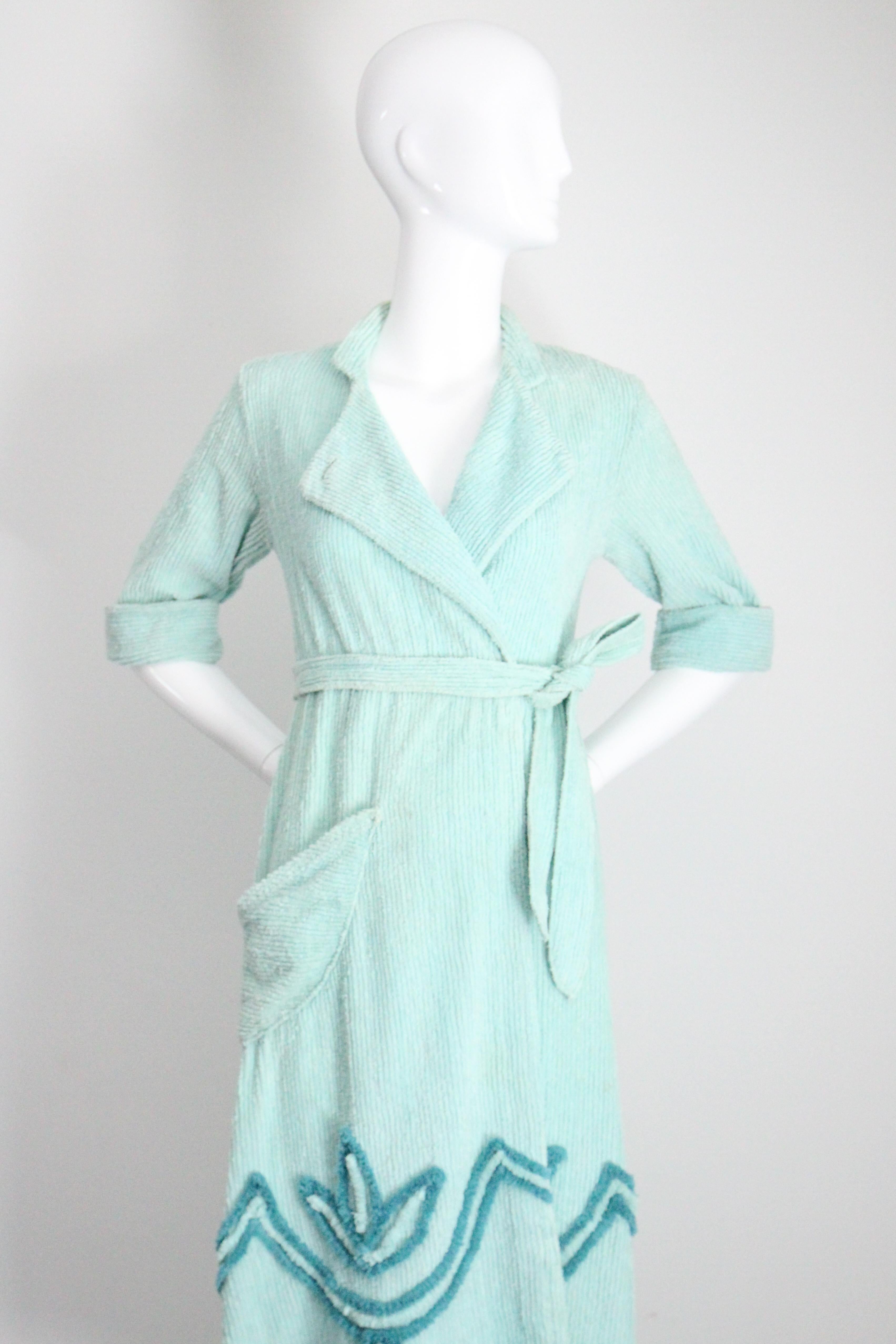Rendered in a palette of turquoise blue, this original 1940's chenille dressing gown, accented by a decorative lotus and geometric pattern along the hemline, is a wonderful addition to your loungewear collection.

The V shaped neckline is framed by