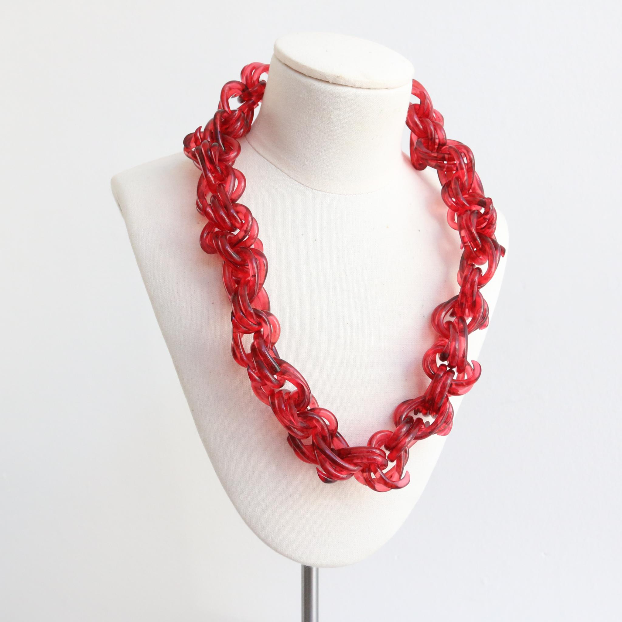 This spectacular 1940's cherry coloured necklace, with an intricate linked and twisted design is a rare piece to behold and the perfect statement piece to add to your jewellery collection. The twisted lucite features link together in a chain design,