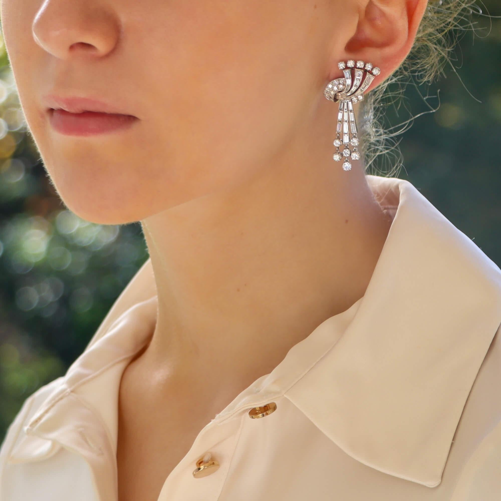  A truly stunning pair of late 1940's diamond drop earrings set in platinum. 

These earrings are beautifully handcrafted and each prominently feature an abstract knot and spray effect design. 

Within each earring the main body is designed as an