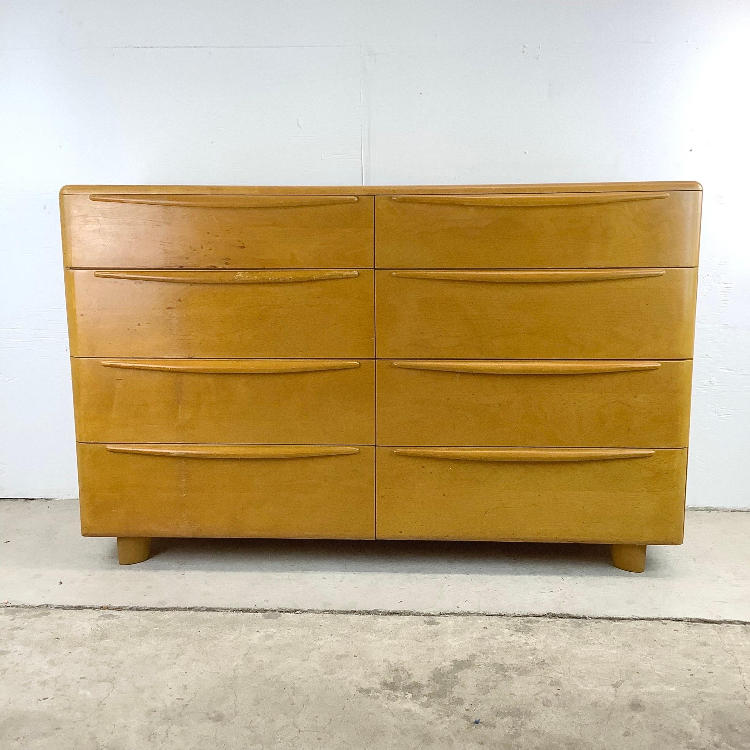 Introducing this vintage 1940s Heywood-Wakefield Eight Drawer Lowboy Dresser, a stunning piece in solid blonde wood construction thats ready to bring timeless beauty and functionality to your bedroom. This exceptional dresser mid-century dresser