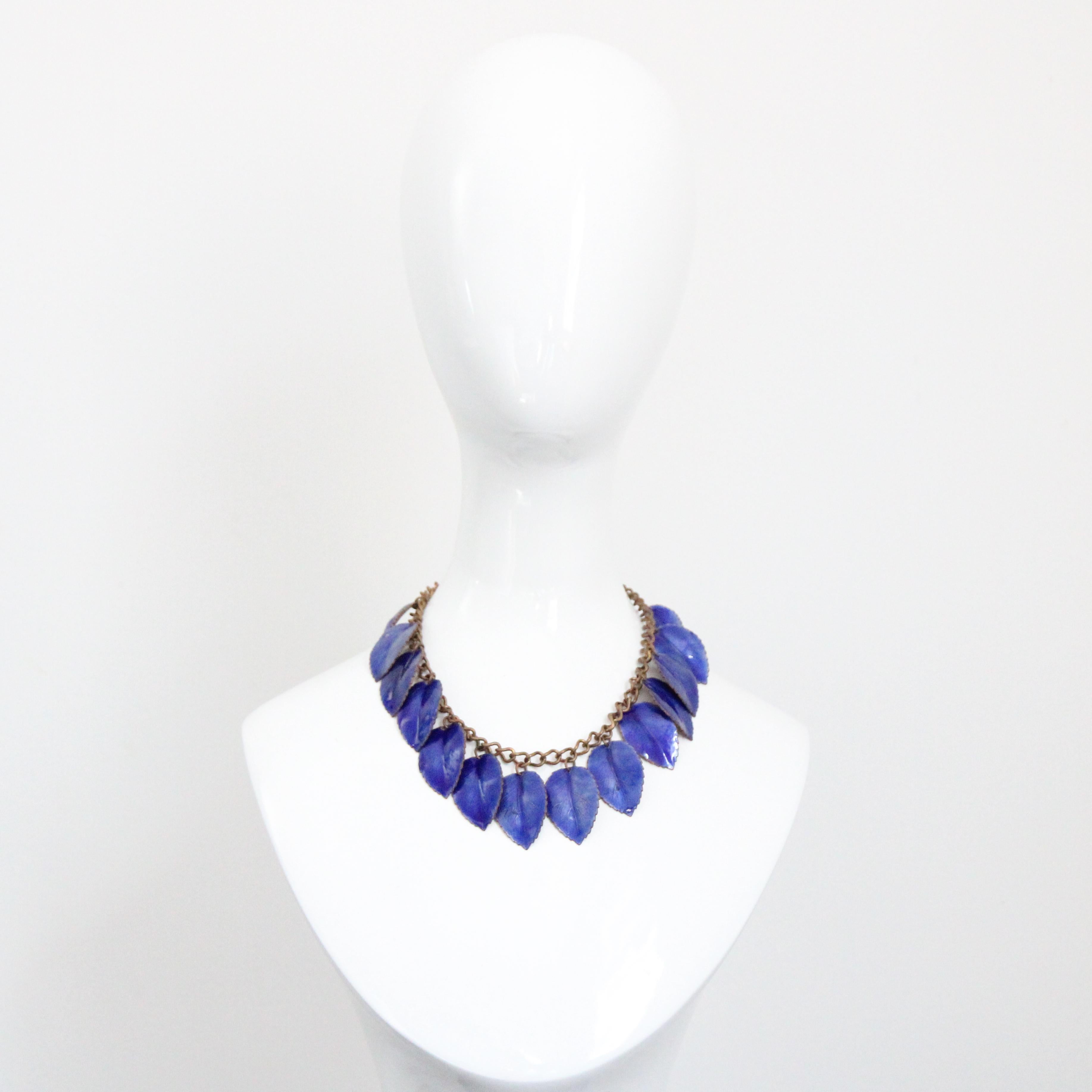 Rendered in the most eye-catching shade of lapis blue enamel, set against copper bases, this original 1940's chain link necklace, decorated with leaf charms is the perfect statement piece to add to your vintage collection. The leaf charms are framed