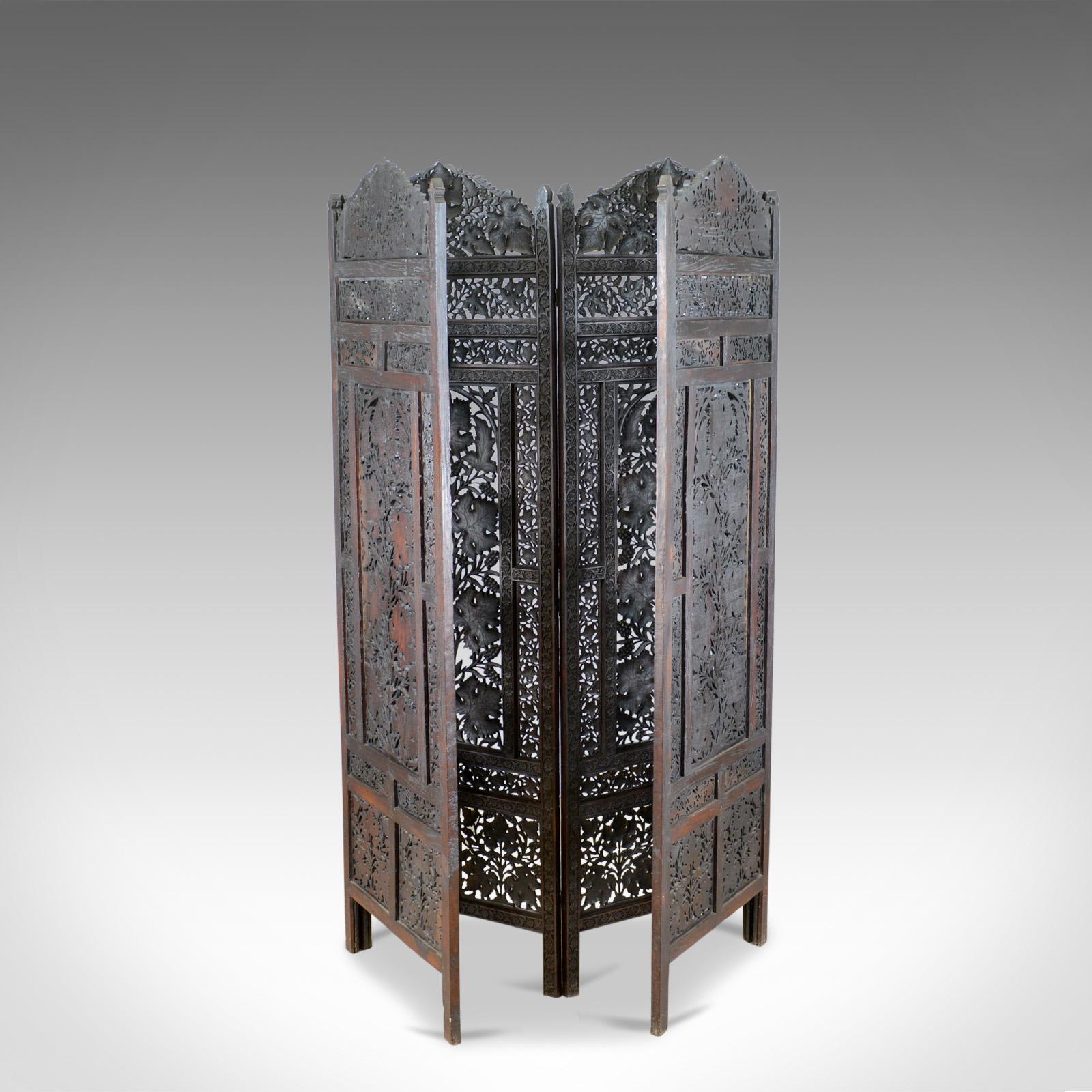 This is a vintage 1940s folding screen, a four-panel screen. A teak, pierced, fretwork room divider perfect as a photographer's prop dating to the Art Deco period.

A profusion of pierced fretwork expertly executed
Tantalising panels of carved