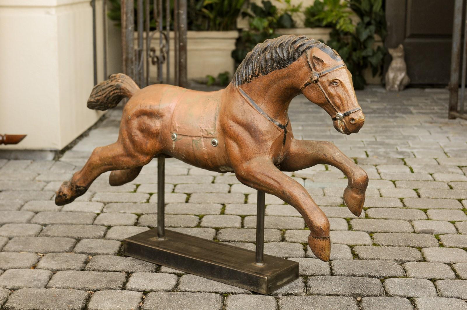 A vintage Folk Art painted iron old child riding horse from the mid-20th century mounted on a new custom base. Born in the first half of the 20th century, this charming vintage iron piece features a brown and black painted iron galloping horse