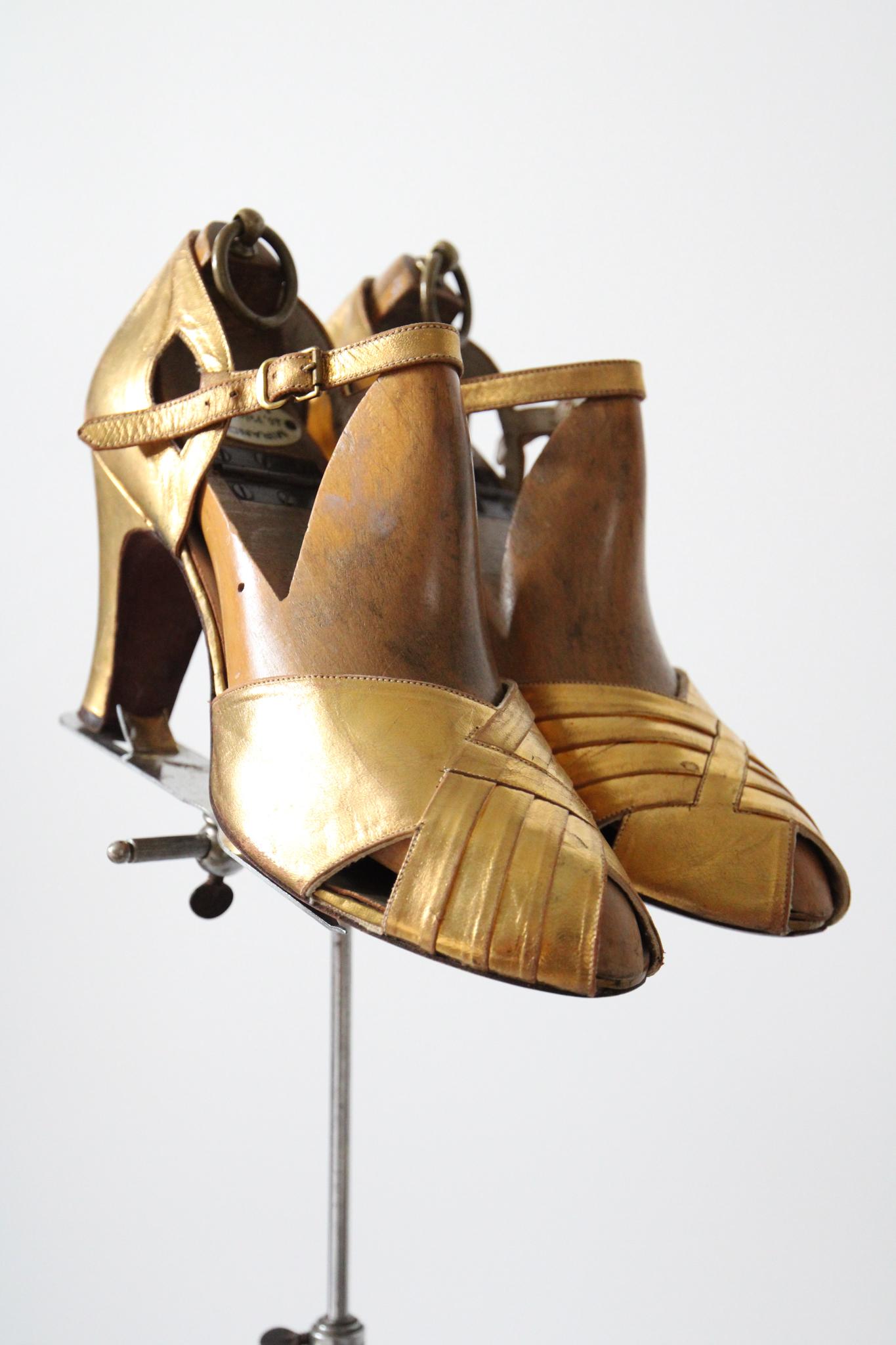 The most breathtaking pair of 1940's heels you could ever hope to set eyes upon.

Her delicate shoe encloses the front of the foot in a rounded peep toe on a slim gold leather base. The vamp of the shoe is accented by a cross over cut, with each
