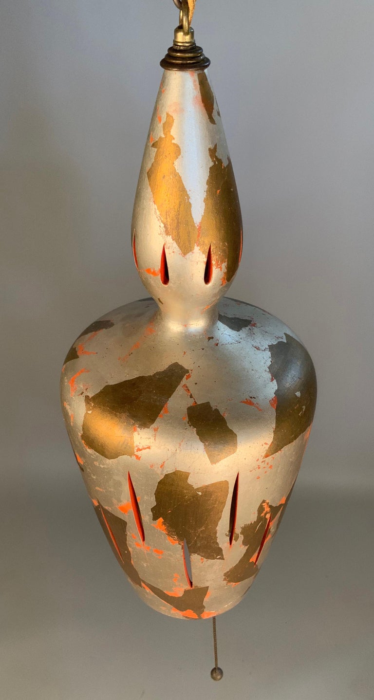 A very nice 1940's ceramic hanging lamp, in bell form, wtih a finish of silver and gold leaf, with bits of orange underneath. wonderful treatment and nice scale and form.