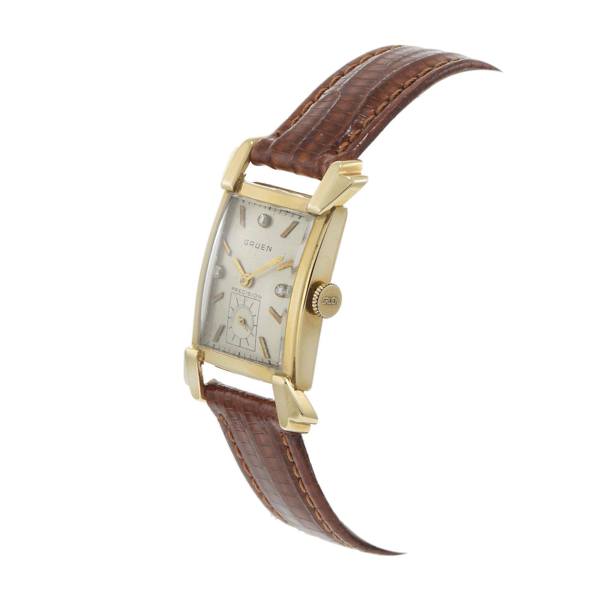 A refined 1940s Gruen dress watch, featuring a 22x25mm 14K yellow gold tank-style case with elegant fancy extended lugs, embodying the sophistication of the era. The silver dial is accented with gold stick and diamond markers, along with a sub-dial