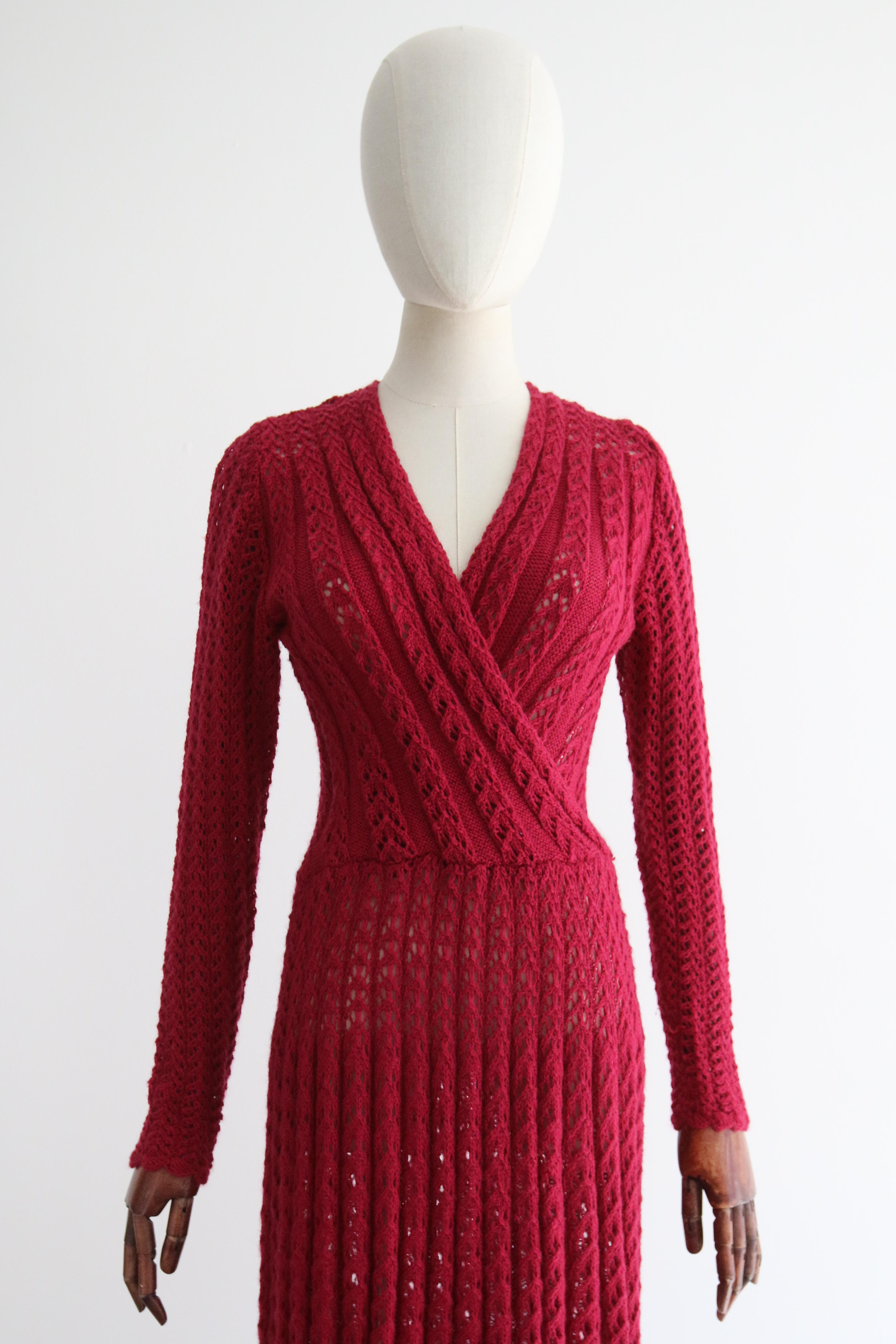 This incredible 1940's magenta knitted dress, rendered in a multitude of different knitted stitches, is just the piece for your transitional wardrobe. 

The deep V shaped neckline is framed by a cross over cut along the bodice which boasts lace