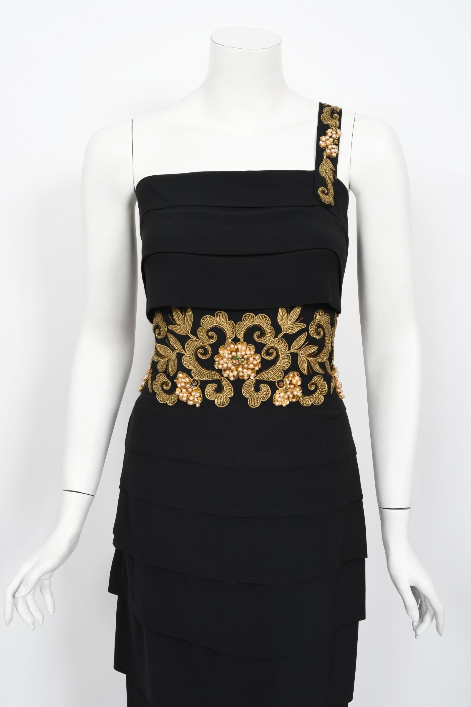 An absolutely stunning and highly coveted metallic gold embroidered and beaded black rayon crepe hourglass gown dating back to the 1940's Old Hollywood era of glamour. The bodice has a seductive asymmetric one-shoulder fitted design. The adornment