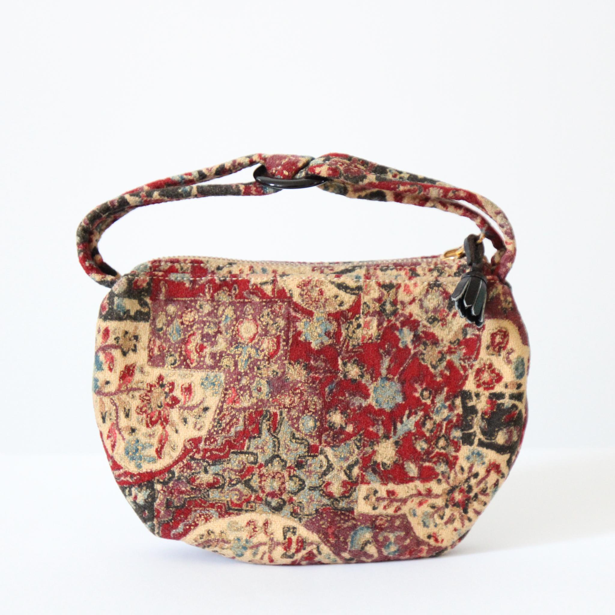 Ce sac à main miniature des années 1940, réalisé dans une toile d'écorce à motifs floraux et abstraits, dans des tons crème, rouge foncé, bleu, bordeaux et rose avec des accents peints en or, est l'accessoire parfait à ajouter à votre collection