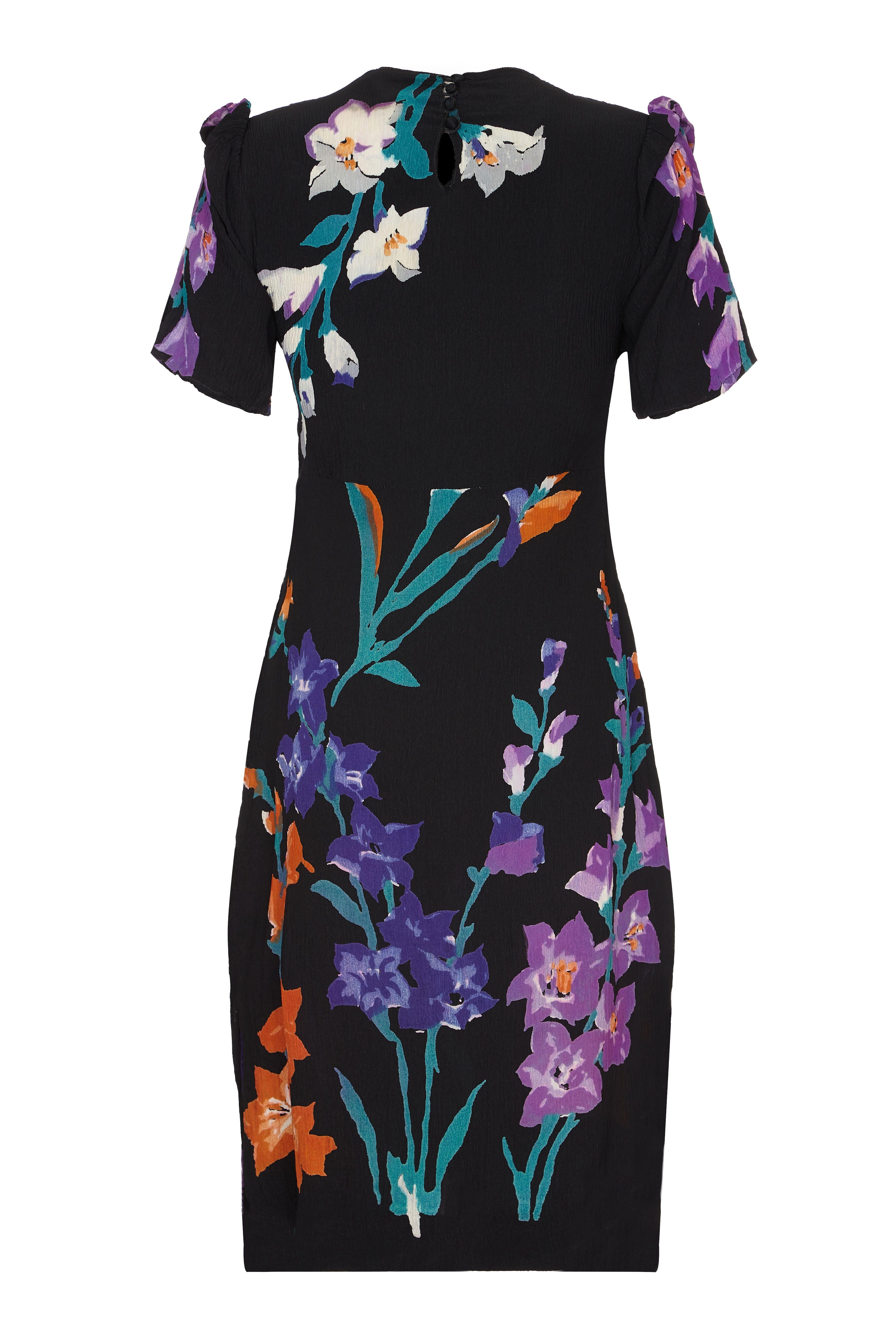 This captivating 1940s silk crepe floral print dress is simple, elegant and in impeccable vintage condition. A large abstract floral design adorns the lightweight crepe in deep orange, lilac, violet and jade green contrasting beautifully with the