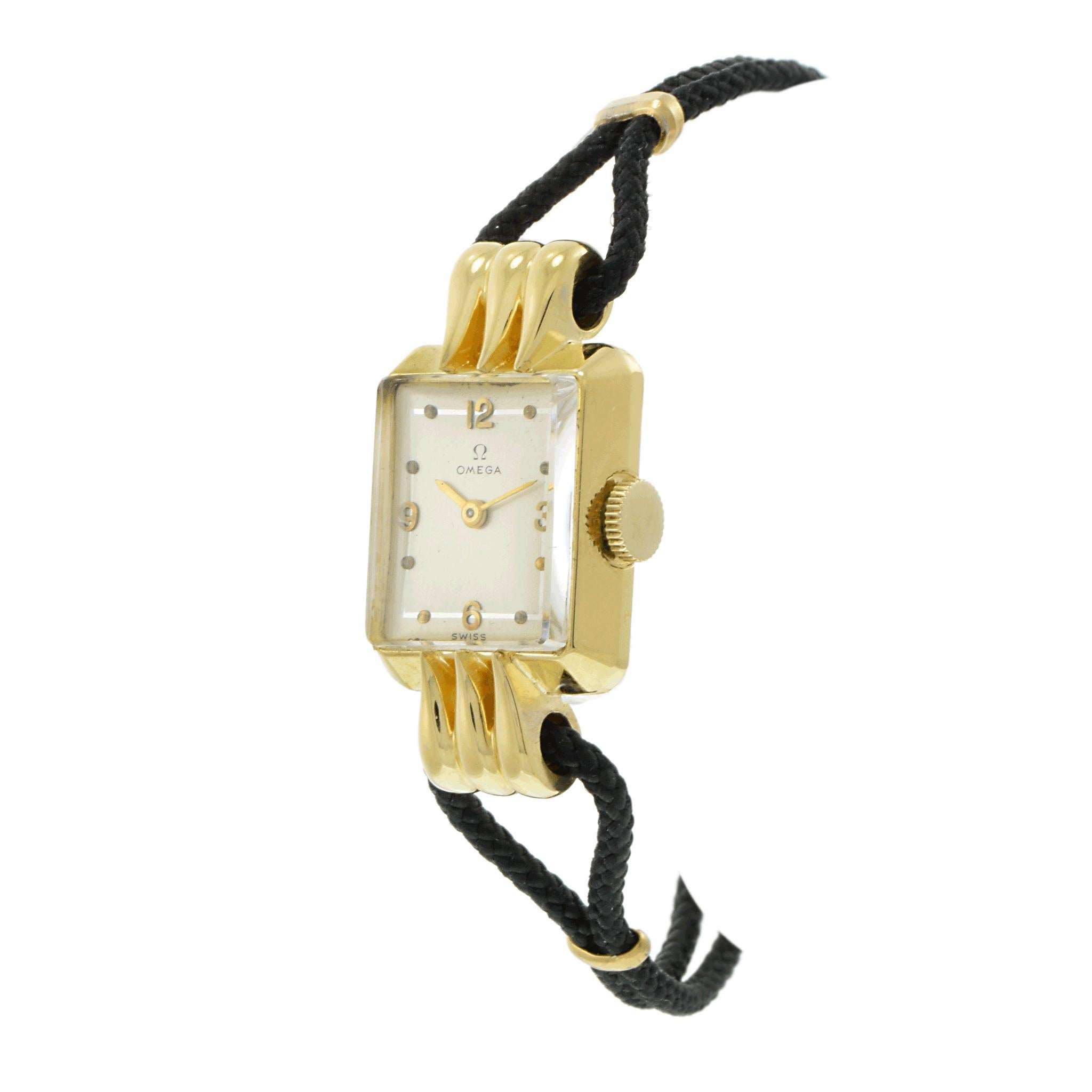 Eine atemberaubende Omega-Damen-Cocktailuhr aus den 1940er Jahren mit einem rechteckigen Gehäuse aus 14 Karat Gelbgold und eleganten, ausgefallenen Bandanstößen. Das silberne Zifferblatt ist mit goldenen arabischen Ziffern und Punktmarkierungen