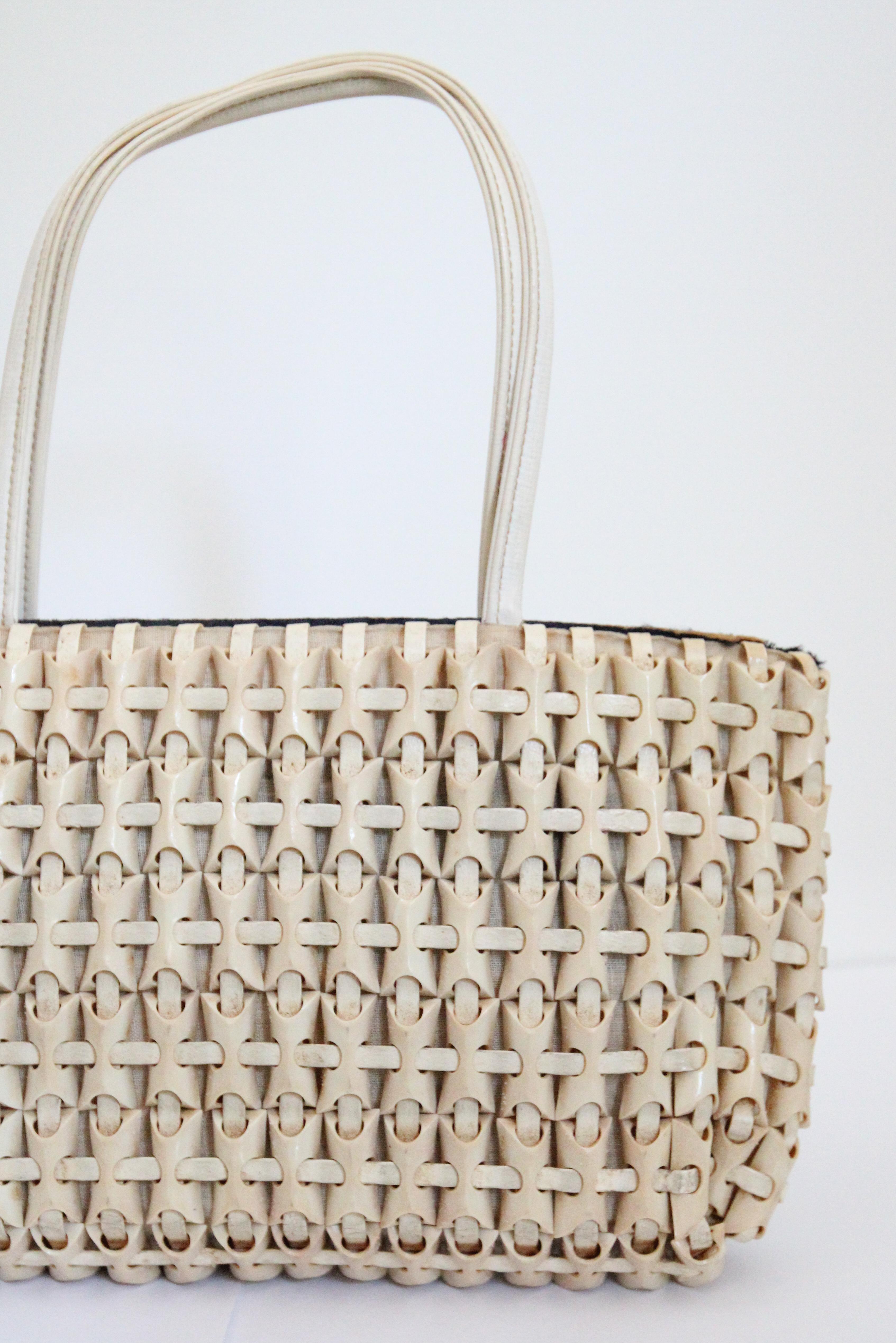 This statement vintage 1940's cream Plasticflex bag, composed of cream rectangular domed tiles with interwoven painted laces in a matching shade of cream set against a cream cotton base, is a timeless accessory for any vintage lover.  

The