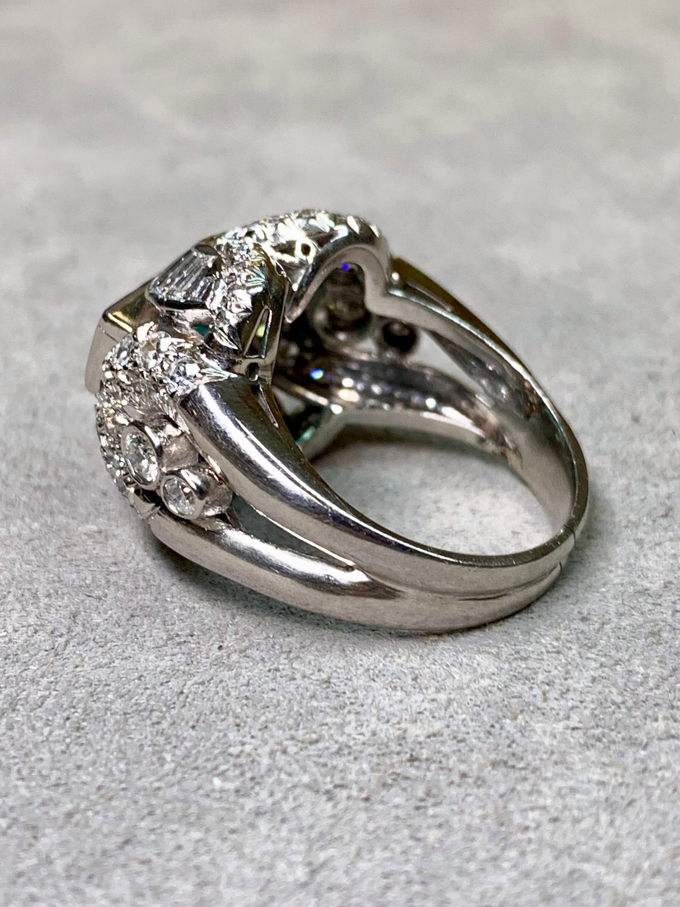 Uno splendido anello da cocktail in platino vintage degli anni '40, centrato da uno smeraldo naturale riccamente colorato in una classica incastonatura a castone - probabilmente di origine colombiana. Lo smeraldo è circondato da un'elegante