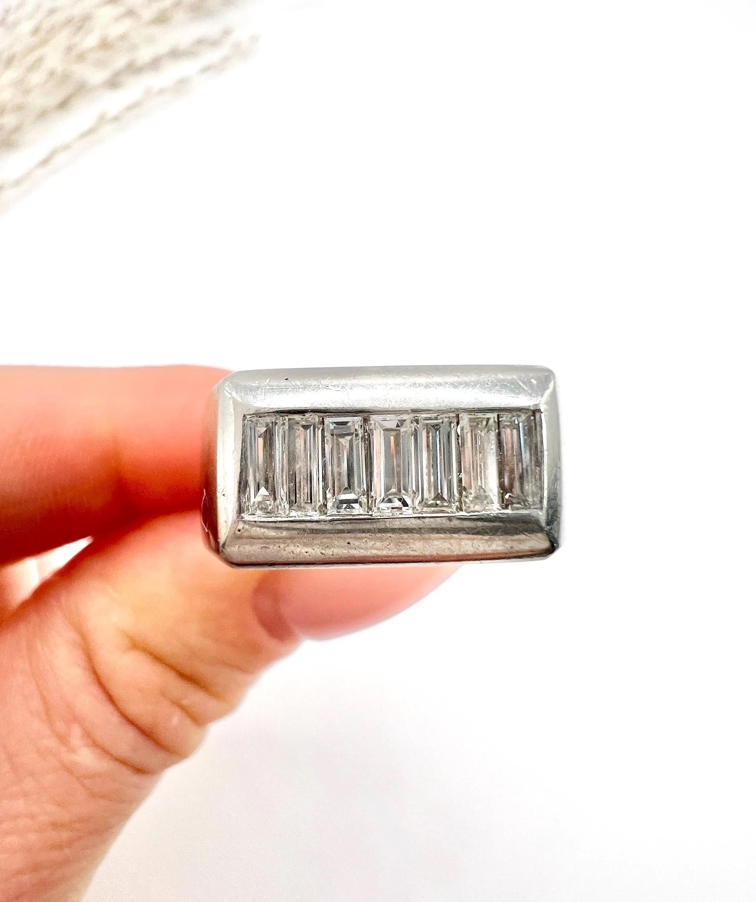 Vintage Cocktail Ring 

Platinum Stamped 

Circa 1940s

Elevate your style with this stunning vintage tank-style ring, expertly crafted from platinum and featuring a unique rectangular setting. Set with six exquisite baguette-cut natural diamonds,