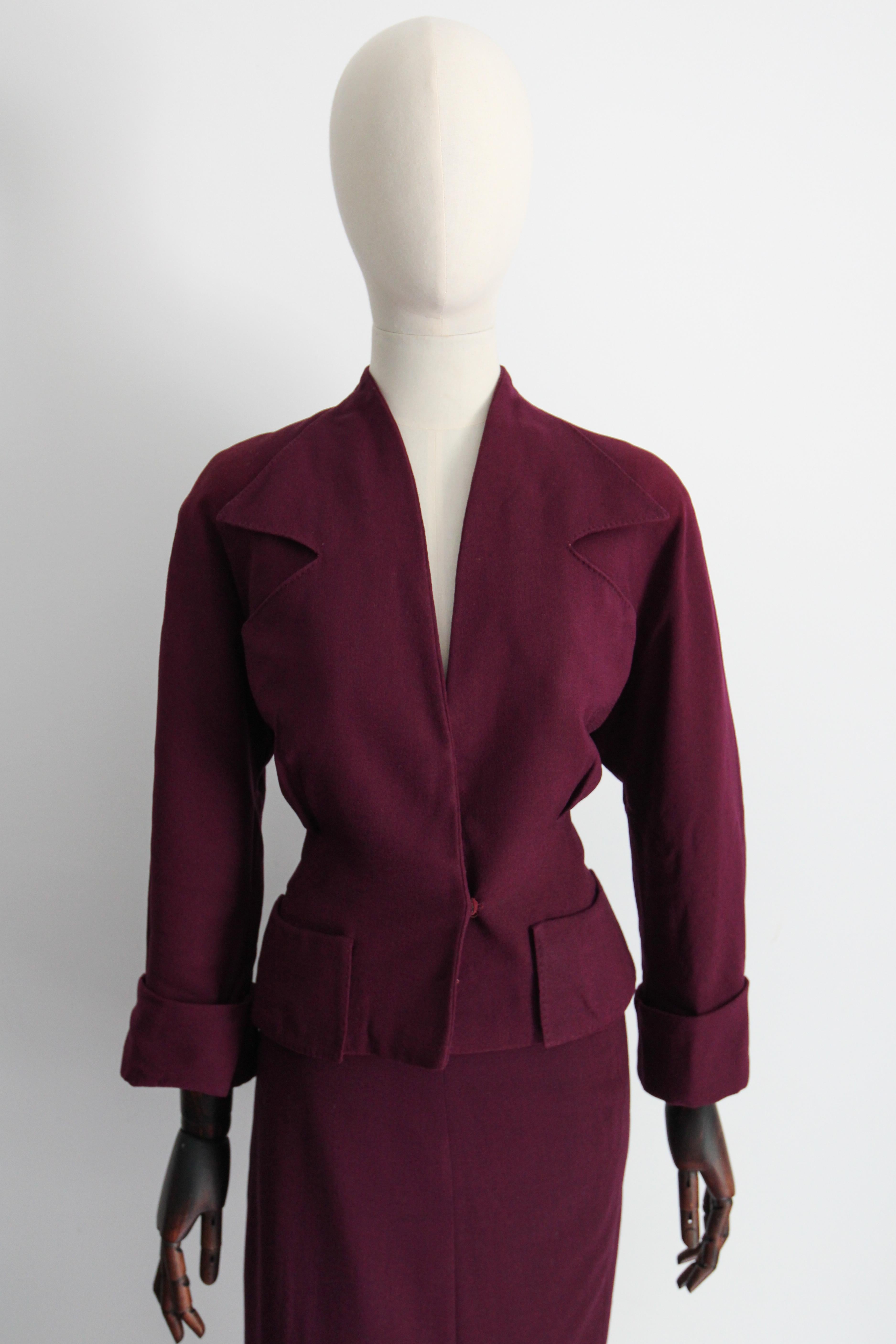 Rendered in the deepest shade of plum in a wonderful crepe wool weave, this original 1940's skirt suit, is just the perfect ensemble for your tailored wardrobe.

The deep V shaped neckline of the jacket, is framed by wide pointed notched lapels,