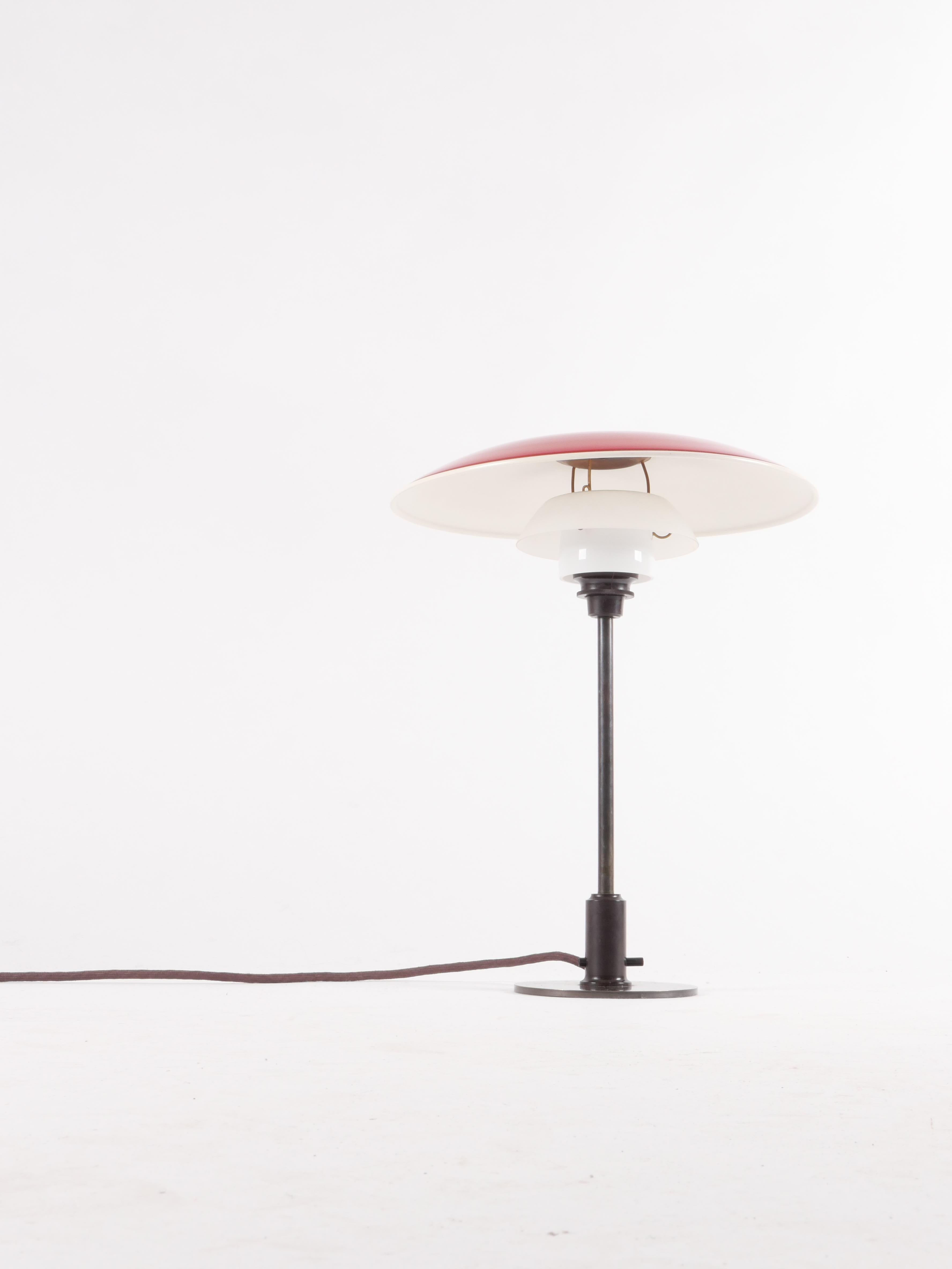 Iconic design by Poul Henningsen in wonderfully patinated brass with original opaline glass diffusers and professionally re-lacquered copper top shade. Newly rewired for European outlets; easily adaptable to US. Rare example lamp in beautiful