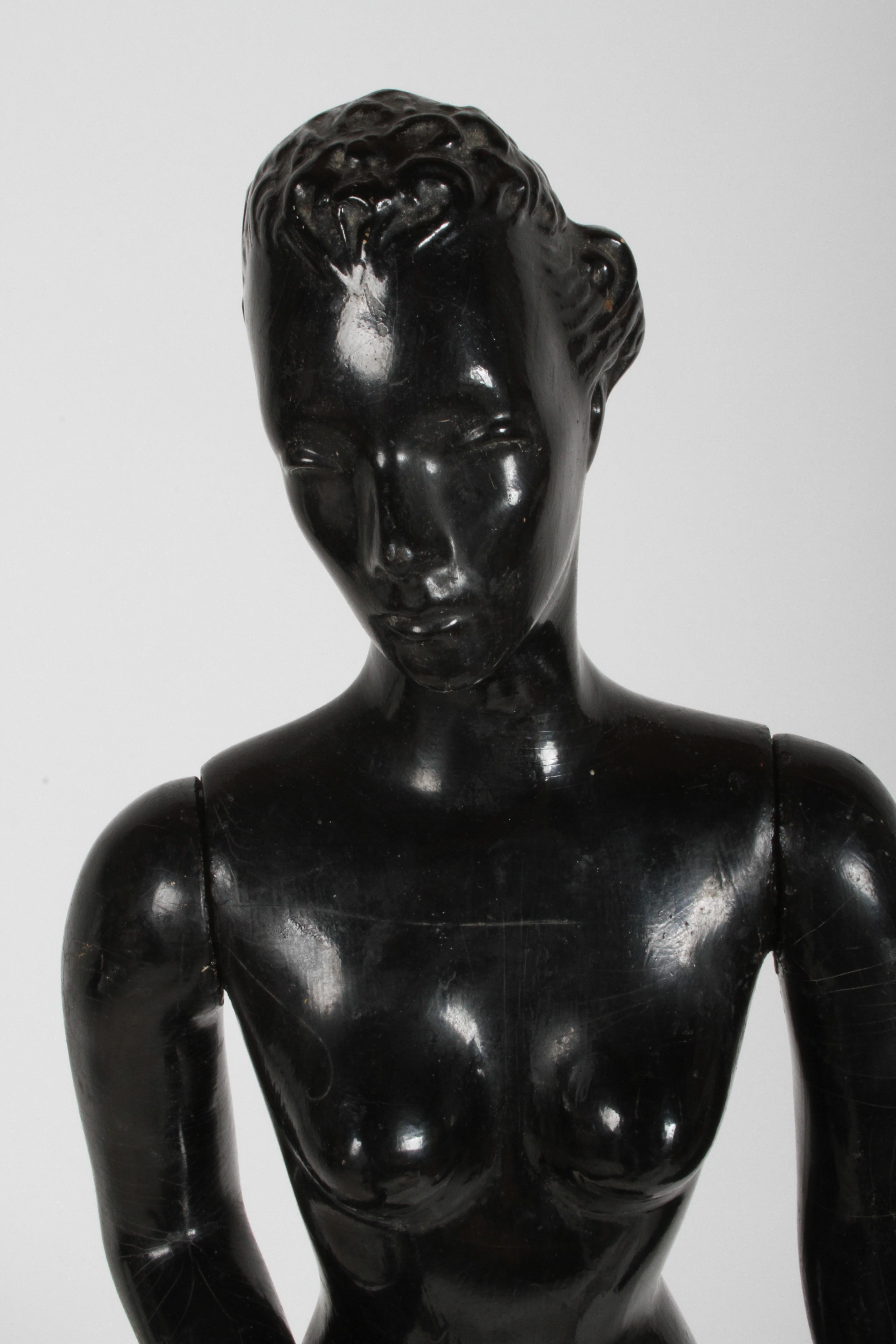 Vintage grand magasin des années 1940 vente au détail comptoir femme mannequin ou poupée magasin vêtements présentoir sur base ronde en bois. La peinture noire d'origine montre de l'âge, les bras ont été rattachés, légères retouches à la peinture