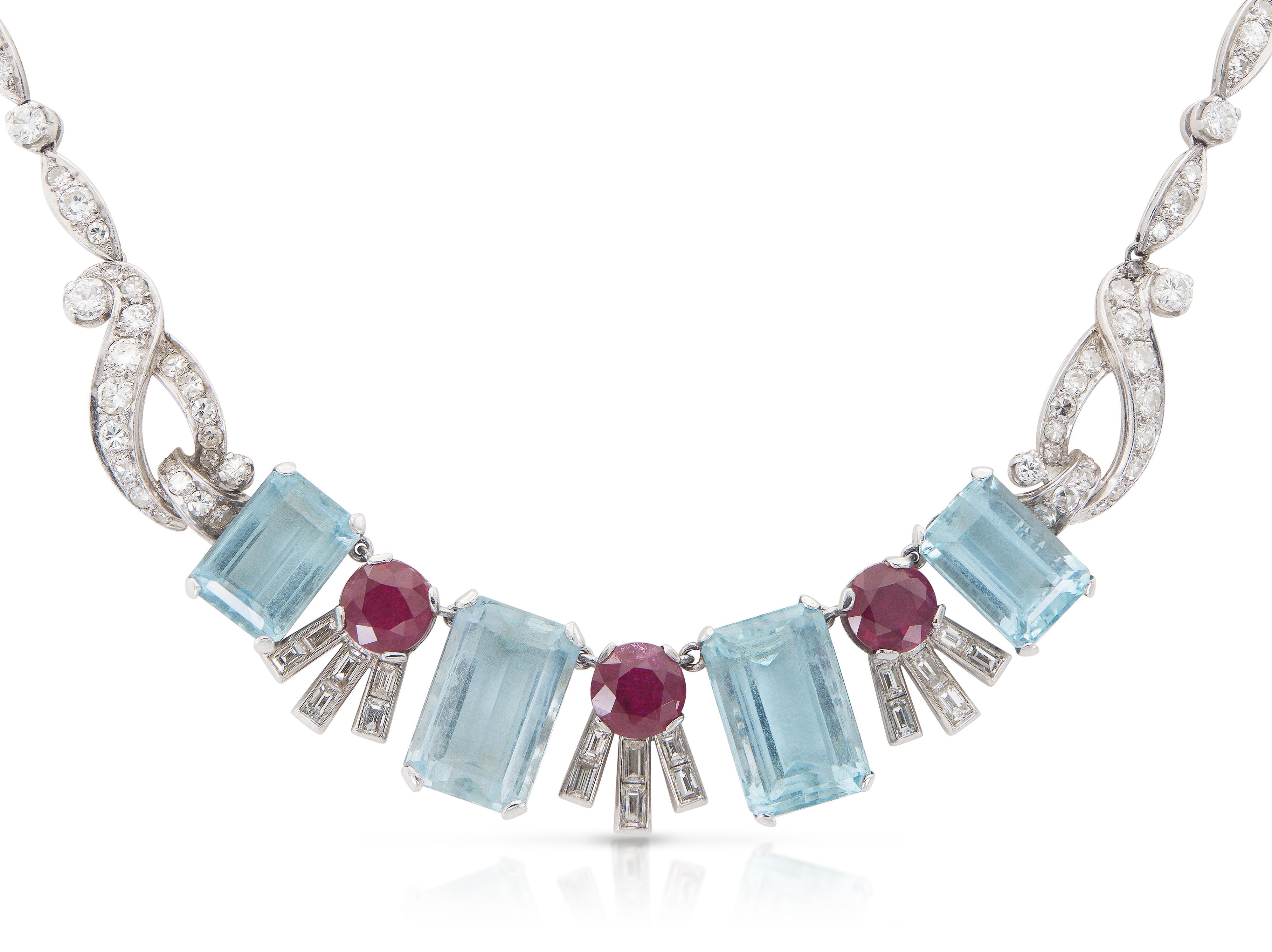 Finemente realizzato in platino con quattro Acquamarine taglio smeraldo per un peso totale di circa 20,00 carati, tre Rubini taglio rotondo per un peso totale di circa 4,60 carati e Diamanti taglio Brilliante e Baguette per un peso totale di circa