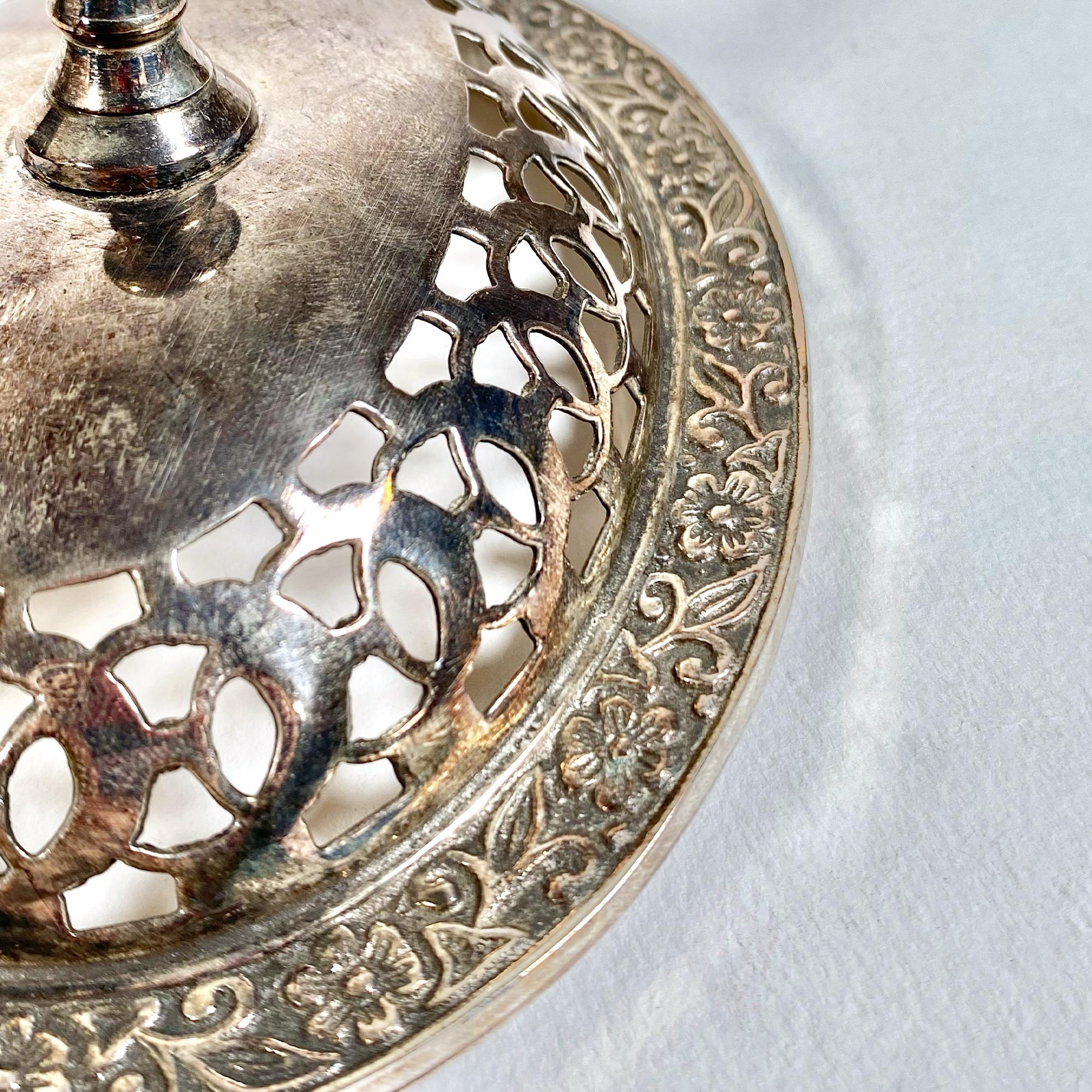Rehaussez votre décor avec cette exquise boîte ajourée en argent datant des années 1940. Cette pièce sans marque dégage un charme ancien qui ne manquera pas d'ajouter une touche d'élégance à n'importe quel espace. Le design ajouré complexe met en