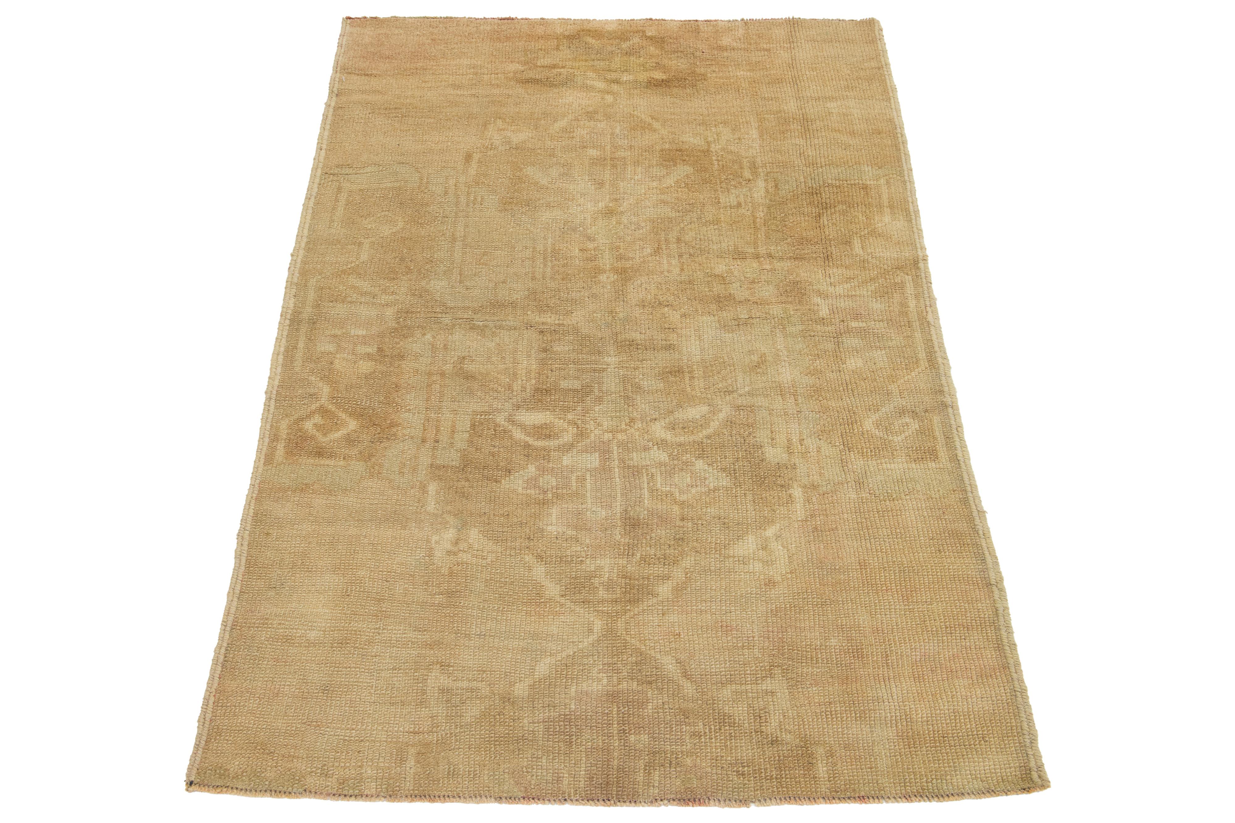 Fabricada en la década de 1940, esta exquisita alfombra turca de Anatolia es una obra de arte atemporal. Fabricado con lana de primera calidad, su cálido tono tostado y su intrincado diseño hecho a mano reflejan la rica herencia cultural de la