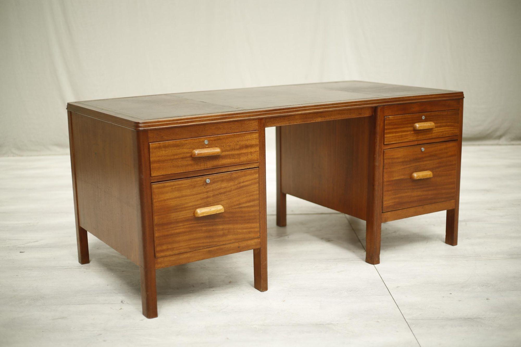 This is a very nice quality 1940's teak desk with leather top. The top is a great colour with a patinated brown and gold accents. It works very well with the teak body which is in great condition. There are two drawers either side. Both large with