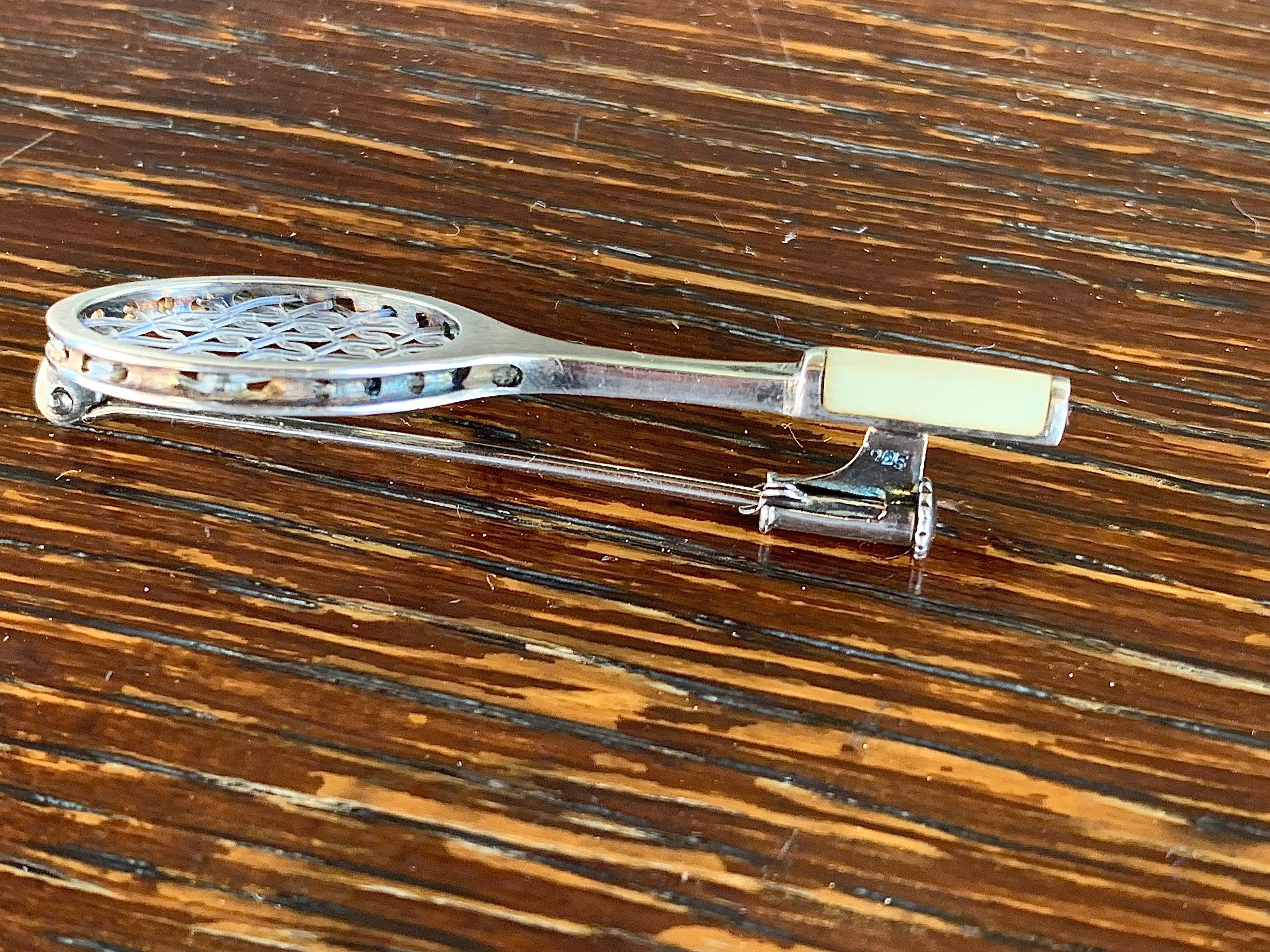 Questa incantevole spilla a forma di racchetta da tennis è stata creata negli anni '40. È contrassegnato dalla sigla 925 per l'argento sterling appena sopra la chiusura di sicurezza. Al centro del collo della racchetta è presente un marchio di