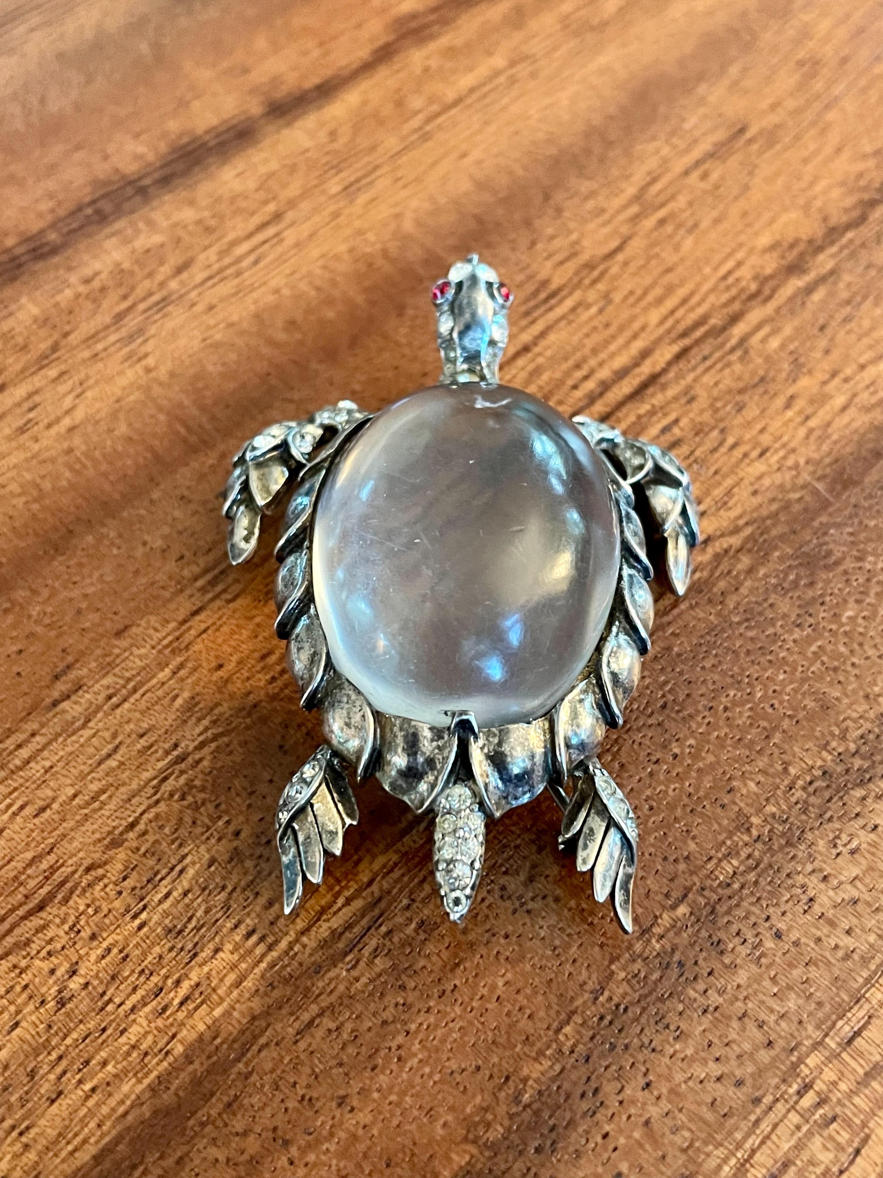 This striking vintage 1940's Trifari brooch features a jelly belly sea turtle with a clear Lucite belly and red rhinestone eyes.

Stamped:  TRIFARI STERLING PATENT NO.

Dimensions: 1 5/8