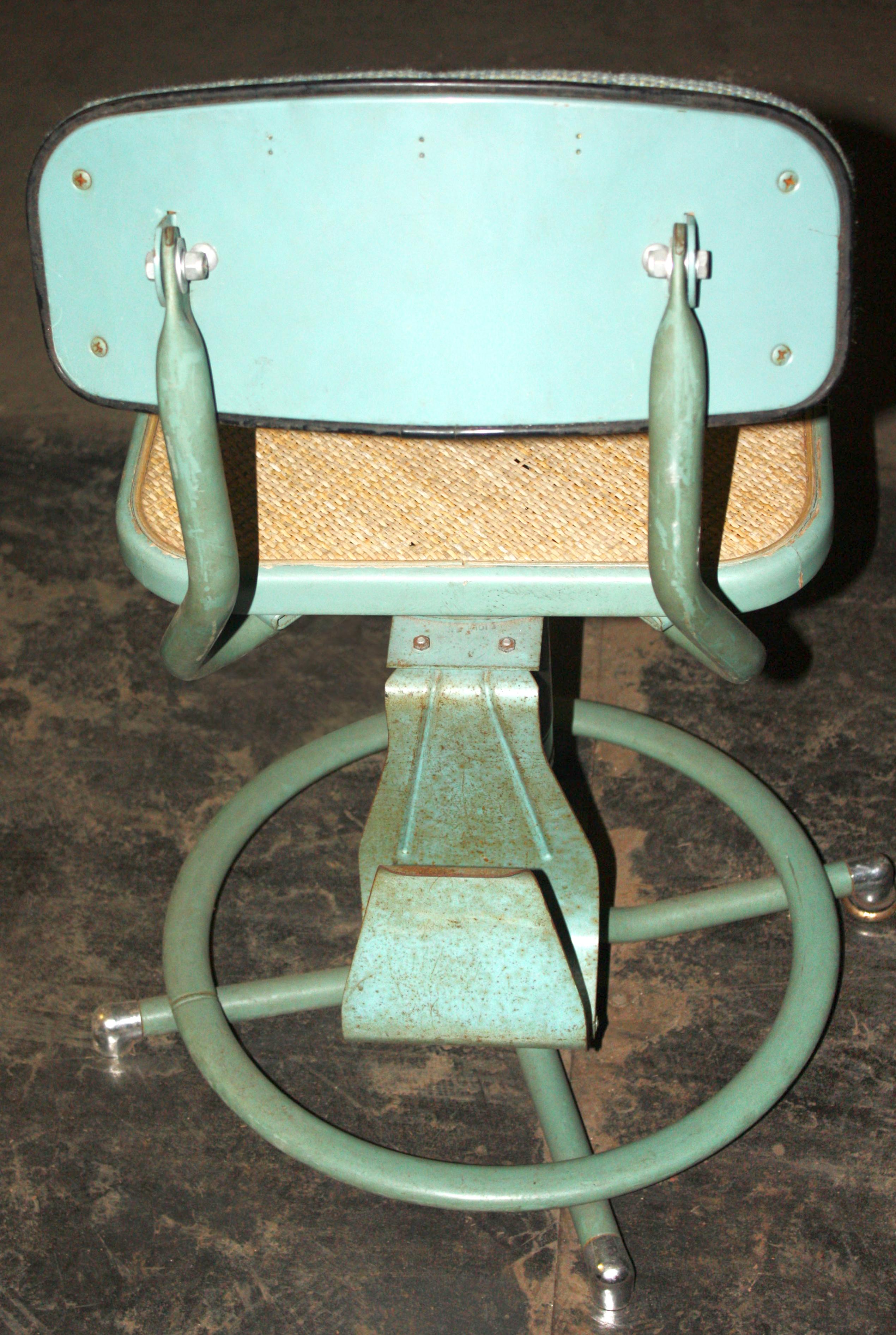 This is an original vintage Western Electric telephone switch board operators stool chair was made circa 1940-1950. Original turquoise enamel finish and caning as well as upholstery on the backrest. The useable height of this chair is 19.5 inches to